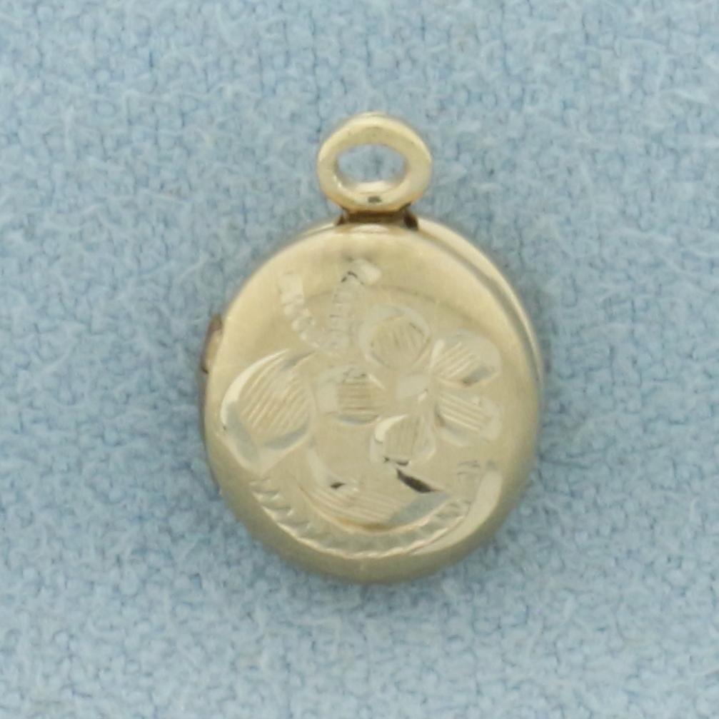 Flower Engraved Small Locket Charm in 14k Yellow Gold: In 14k yellow gold shell, nickel silver frame inside. 1/2 inches long x 5/6 inches wide. .8g.