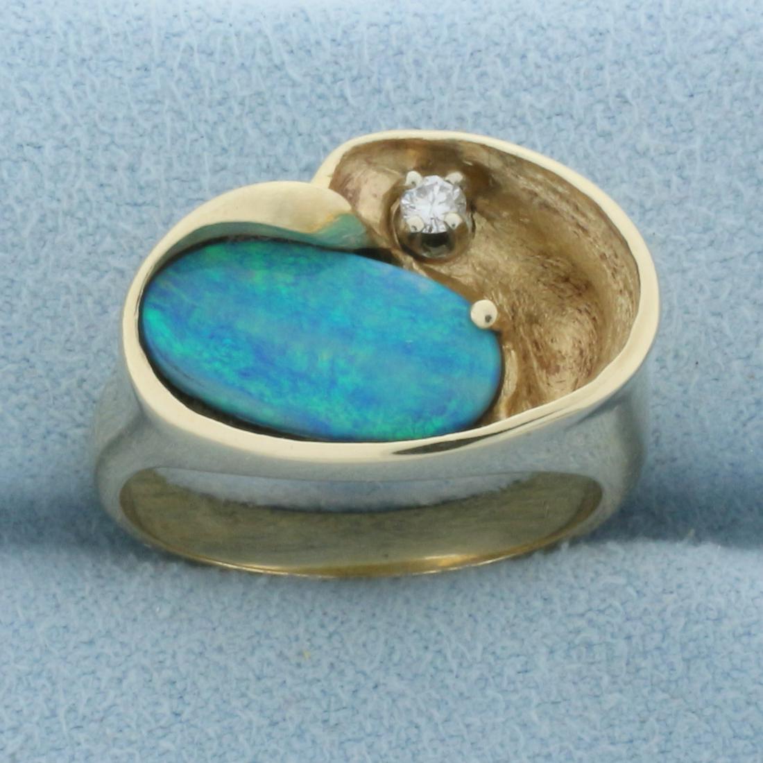 Black Opal and Diamond Ring in 14k Yellow Gold: In 14k yellow gold. Contains a high quality natural 13x7mm doublet black opal with intense blue and green color. Also contains a high quality .05ct diamond, VS clarity/H color. Size 7.25