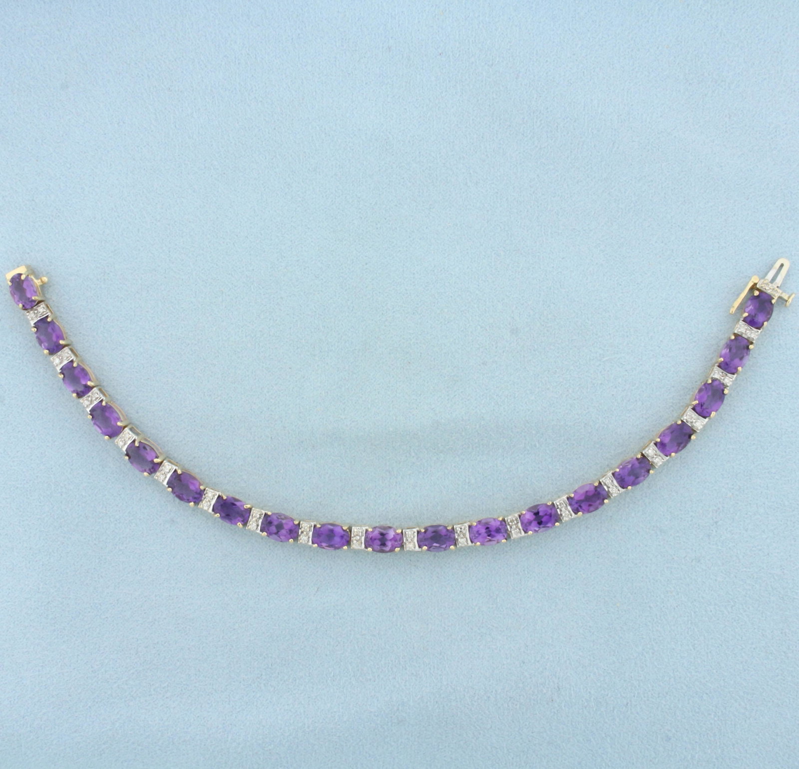Amethyst and Diamond Tennis Line Bracelet in 14k Yellow gold: In 14k yellow gold. Contains 19 high quality natural 1ct oval cut amethyst gemstones, with intense color and excellent clarity. Also contains thirty eight 1/2pt diamonds. 7 inches long, concealed slid
