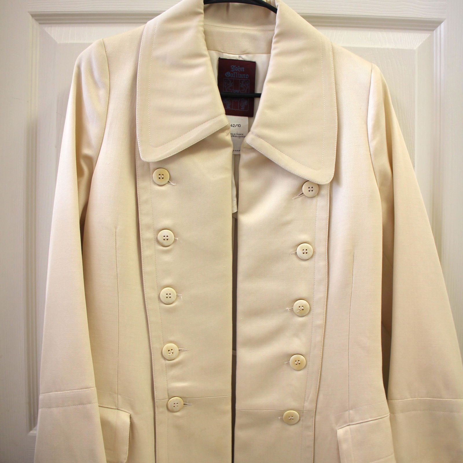 John Galliano Off White Long Dressy Trench Coat: Size 42. Vintage John Galliano. Made in France. All original. Partially lined inside. Expertly crafted. In beautiful vintage condition with some minor imperfections/stains.