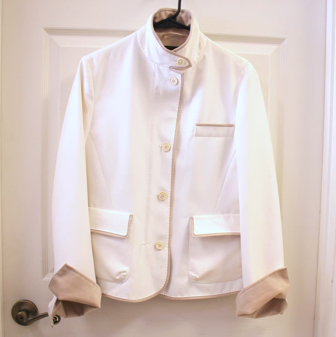 Loro Piana Cashmere Lined Storm System Jacket Coat: Size 44. Loro Piana logo embroidered on back collar. 100% cashmere lined. Storm system rain and wind protection. 2 way zipper. Iconic ivory and tan/beige colorway. Original quiet luxury fashion house.