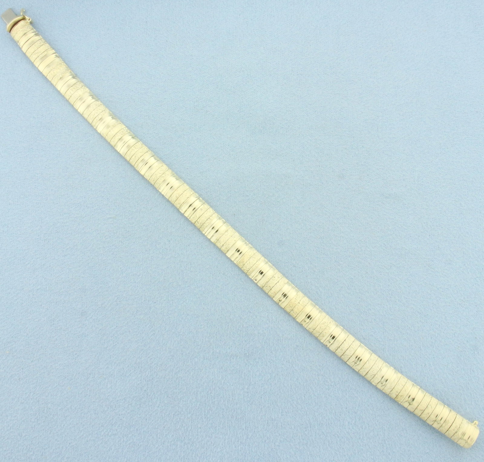 Italian Sand Blast and High Polish Finish Omega Bracelet in 14k Yellow Gold: In 14k Italian made yellow gold. 7 1/4 inches long, 1/4 inch wide. Concealed slide clasp with safety latch. 14.3g.