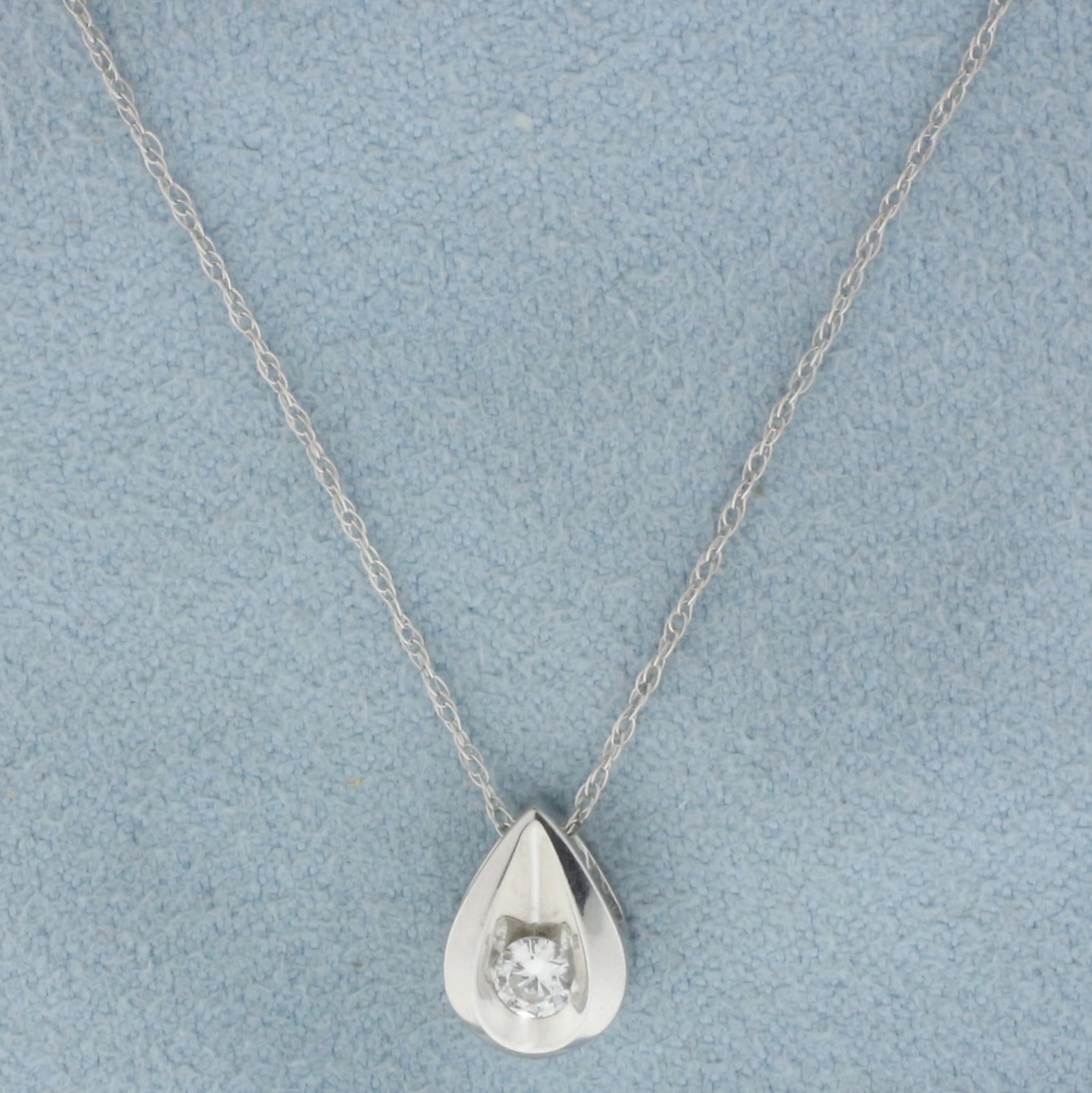 Diamond Dew Drop Design Pendant on Chain Necklace in 14k White Gold: In 14k white gold. Contains one high quality 1/8ct round brilliant diamond, SI clarity/F color. Pendant is 3/8 inch long, 1/4 inch wide. Chain is 18 inches long, .75mm wide, prince of wales link, with