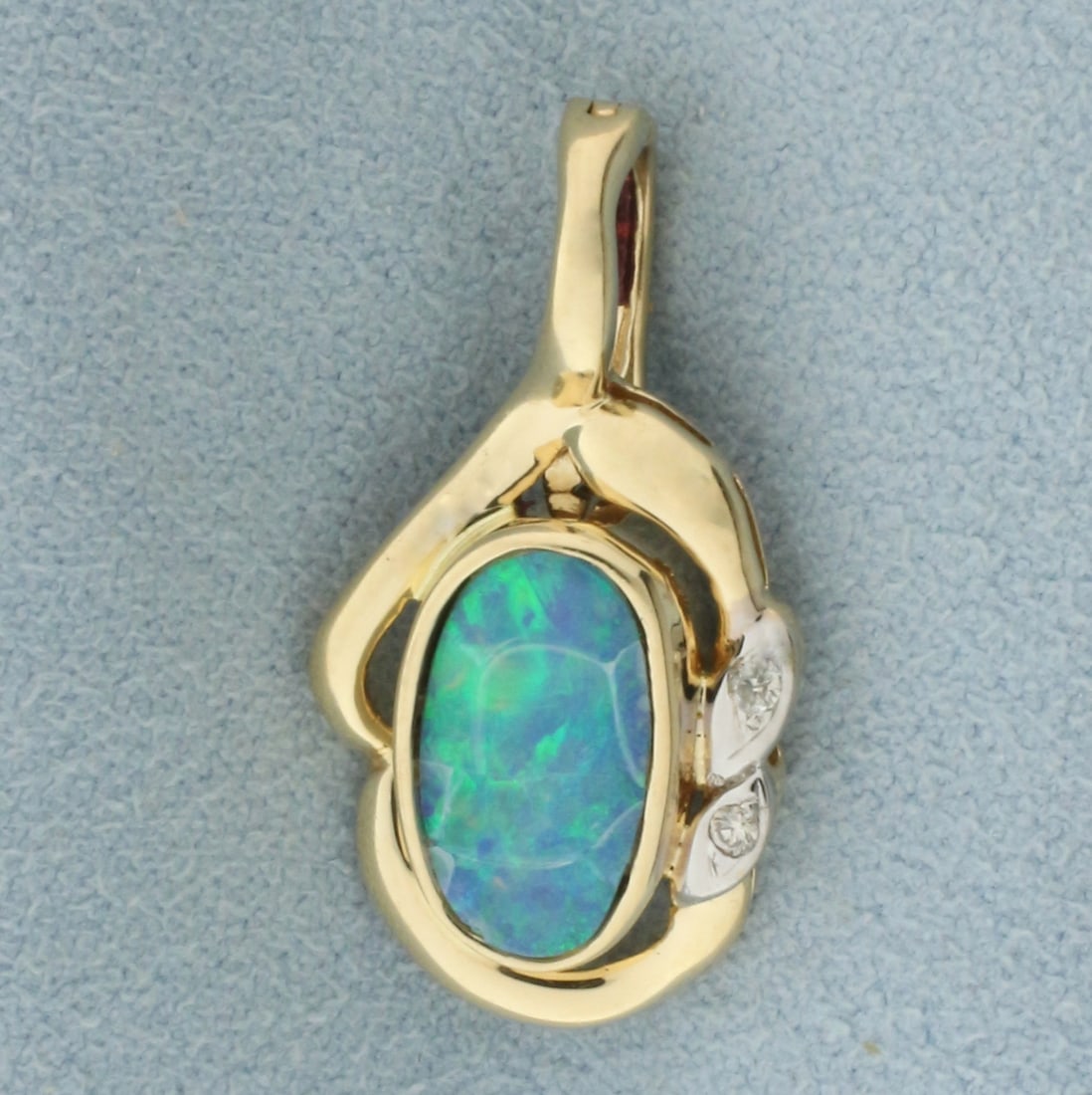 Australian Black Opal and Diamond Pendant in 14k Yellow Gold: In 14k yellow gold. Contains one high quality natural 11mm by 6mm Australian Black opal with intense blue and green color, some crazing. Also contains two high quality .01ct diamonds, VS clarity/H col