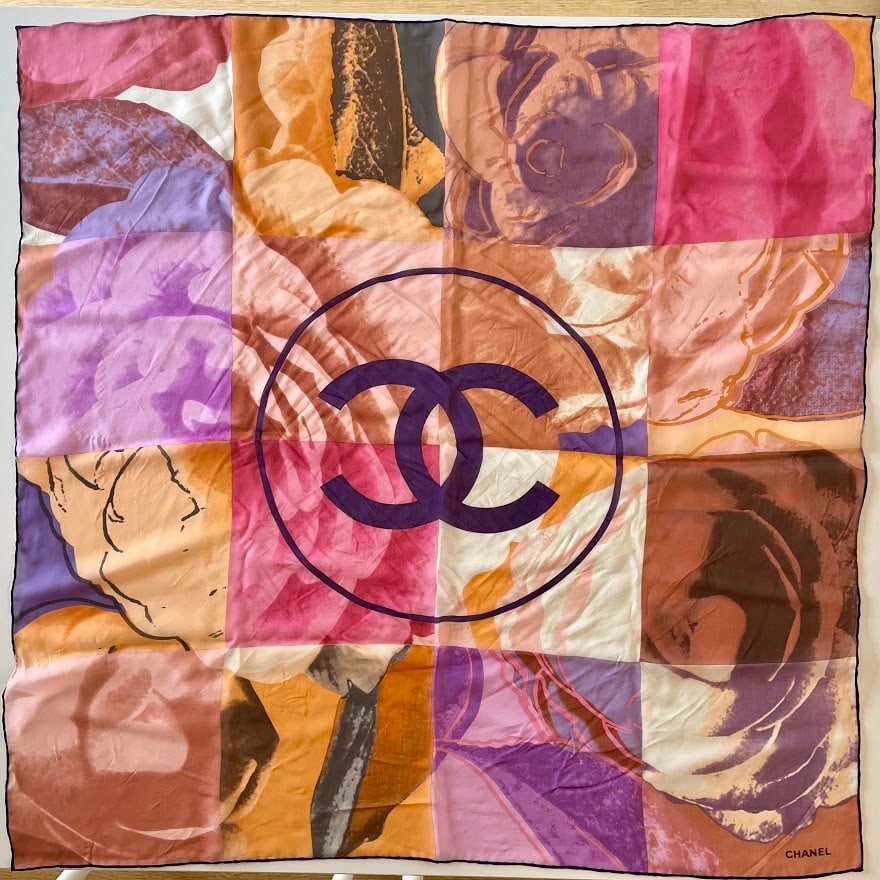 Chanel Vintage Silk Chiffon Flower CC Logo Purple Pink 90 Scarf: Guaranteed authentic with box. Measures approx. 33" x 34" (90cm), 100% silk chiffon, and hand rolled contrast purple edges. Iconic CC logo in center with flower panel art designs. Colors include purpl