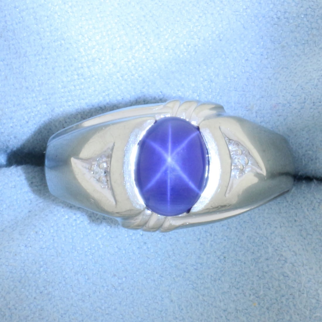 Mens Star Sapphire and Diamond Ring in 10k White Gold: In 10k white gold. Contains one high quality 9mmx7mm oval cabochon star sapphire with very distinctive star under light. Also contains two .01ct diamonds, SI clarity/H color. Size: 11.5. 5.5g.