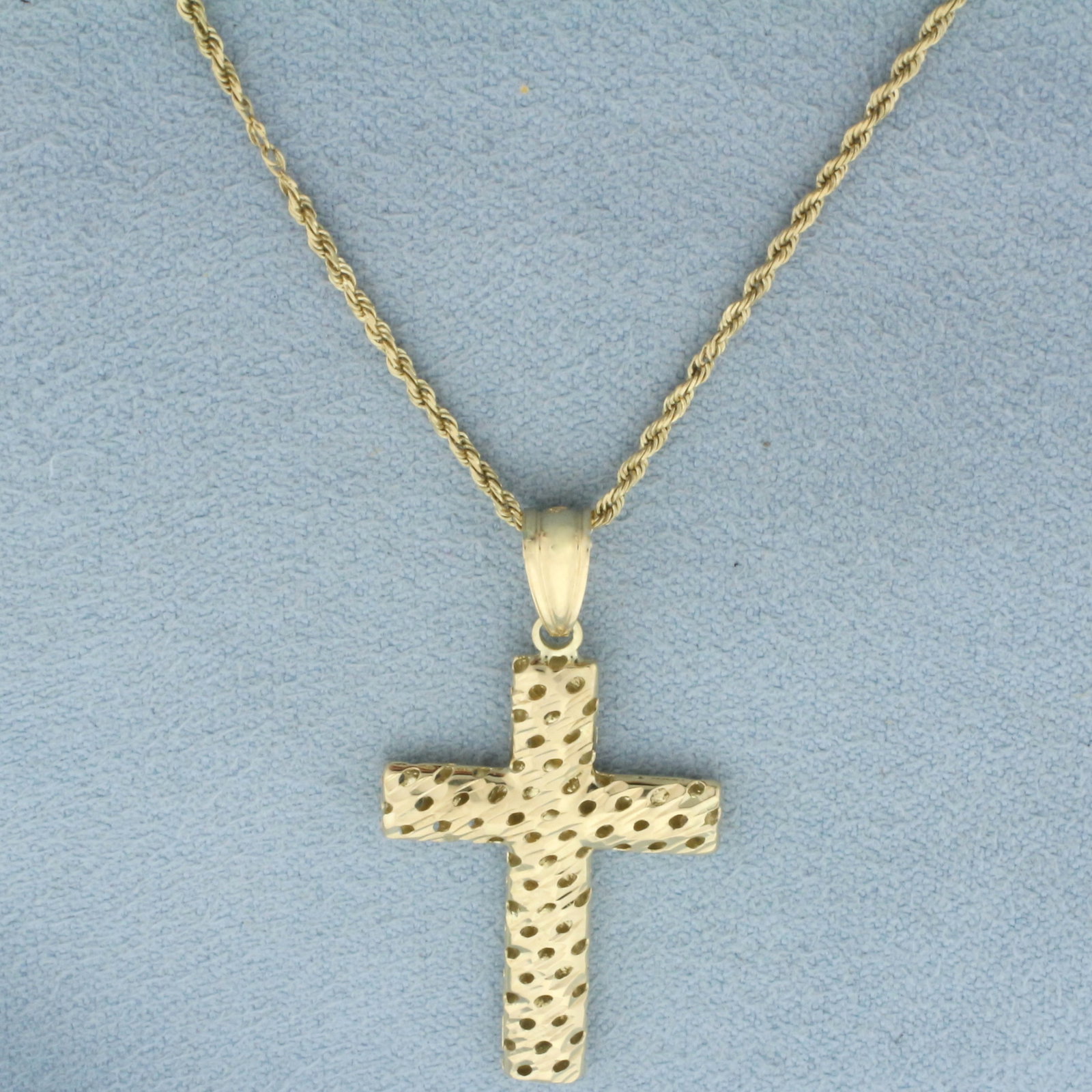 Diamond Cut Cross Necklace in 14k Yellow Gold: In 14k yellow gold. Rope Chain is 18 inches long and 1.1mm wide. Pendant is 1 3/8 inches long and 3/4 inches wide. Spring Ring Clasp. 3.2g.