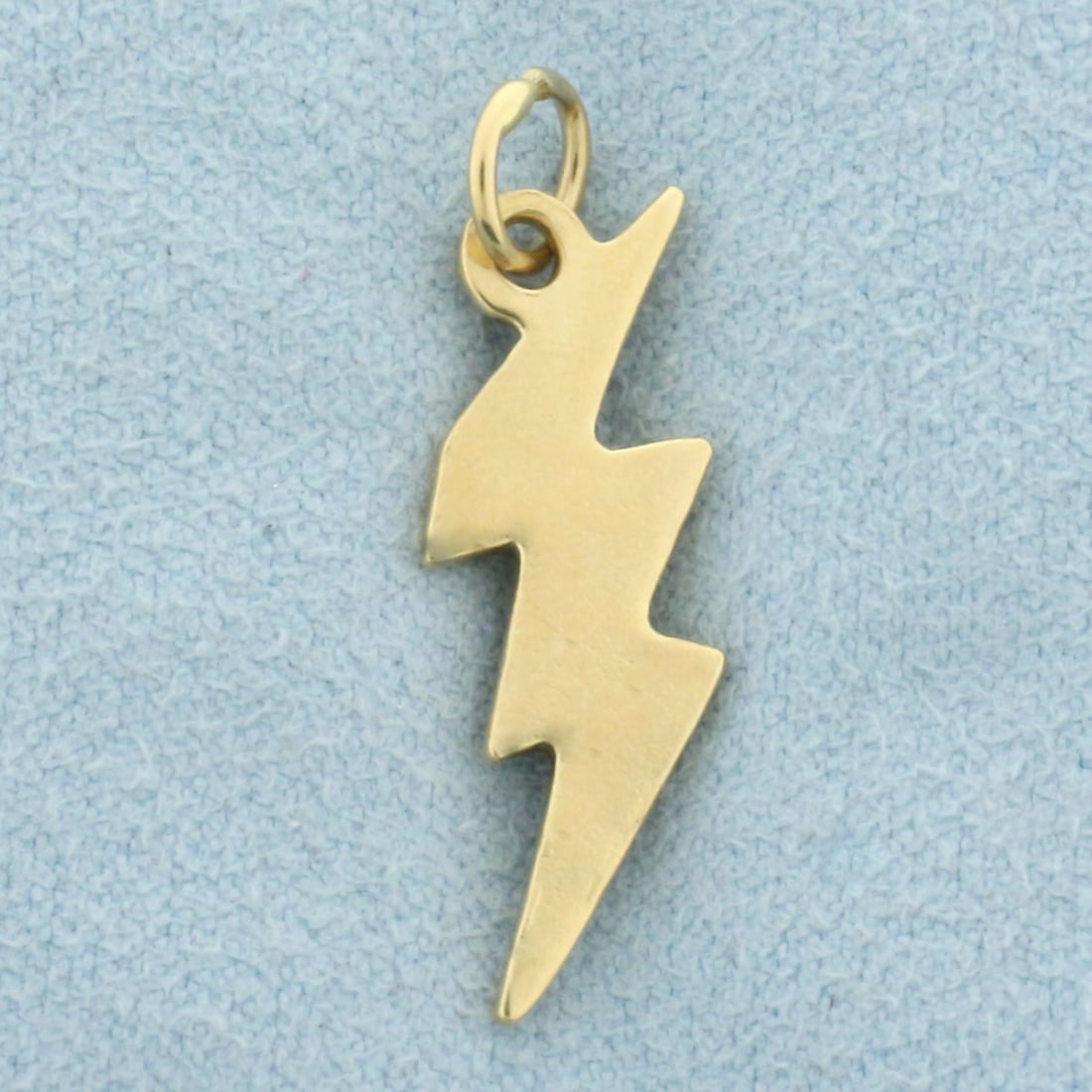 Lighting Bolt Charm or Pendant in 14k Yellow Gold: In 14k yellow gold. 1 1/8 inches long (including jump ring) and 3/8 inch wide. 1.6g.