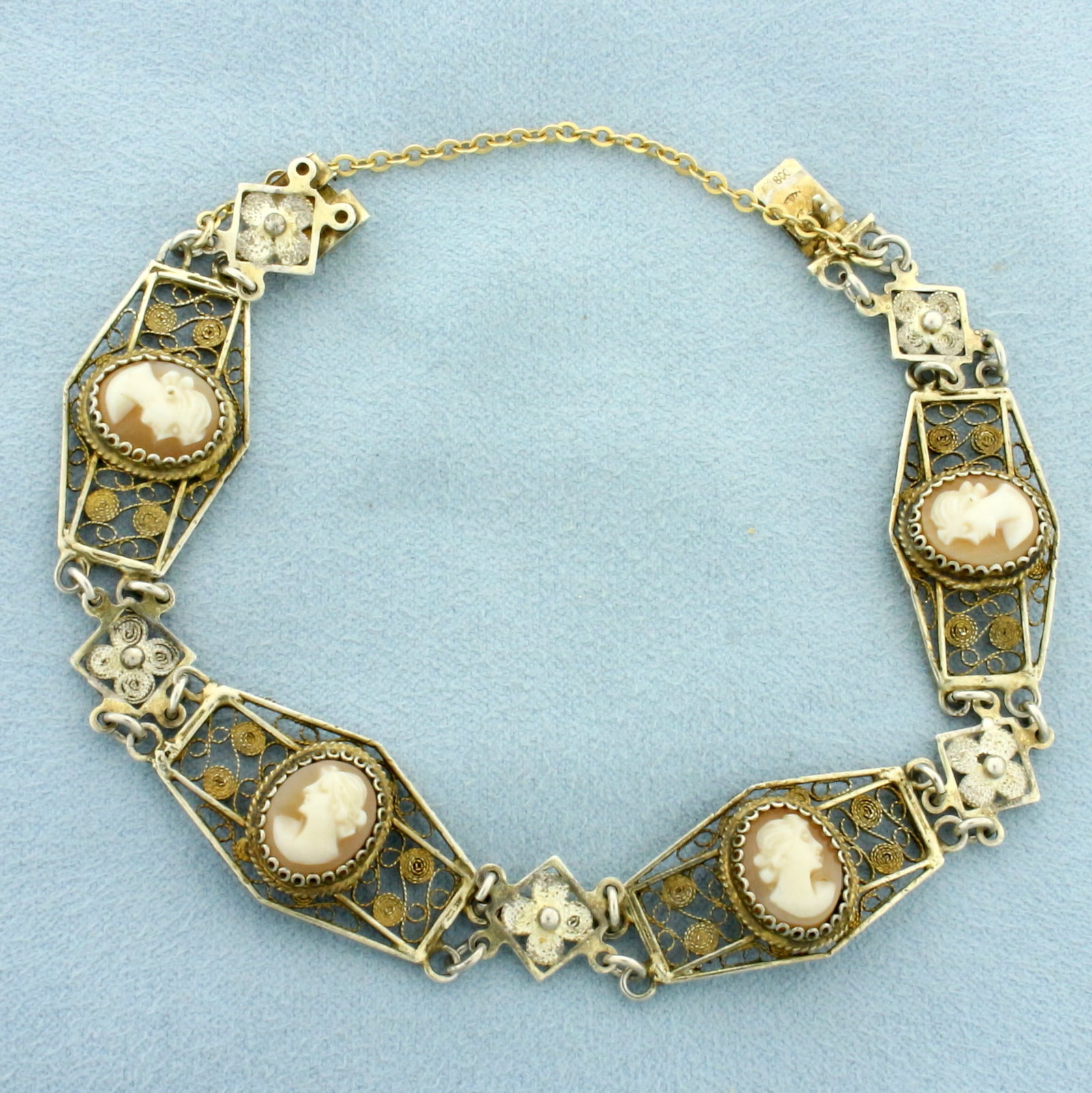 Antique Cameo Silver Bracelet: .800 silver (80% fine silver) with gold plating. Contains four 11mm cameos. 7.5 inches long, 1/2 inch wide at widest point. Concealed clasp with safety chain. 13.1g.