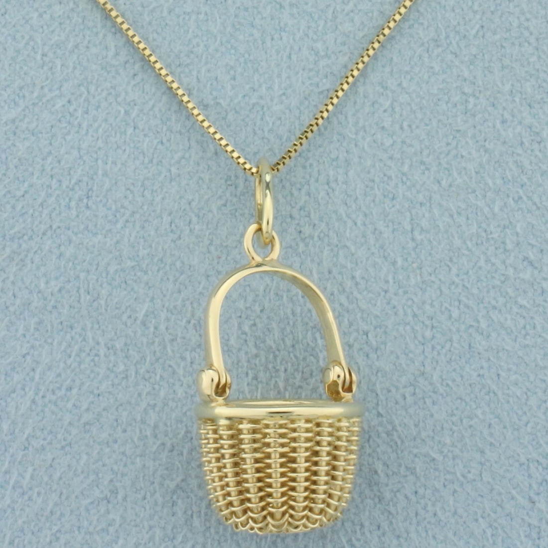 Italian Woven Basket Necklace in 14k Yellow Gold: In 14k yellow gold. Made in Italy. Box link necklace is 20 inches long and .65mm wide. Pendant is 1 inch long. Spring ring clasp. 3.7g.