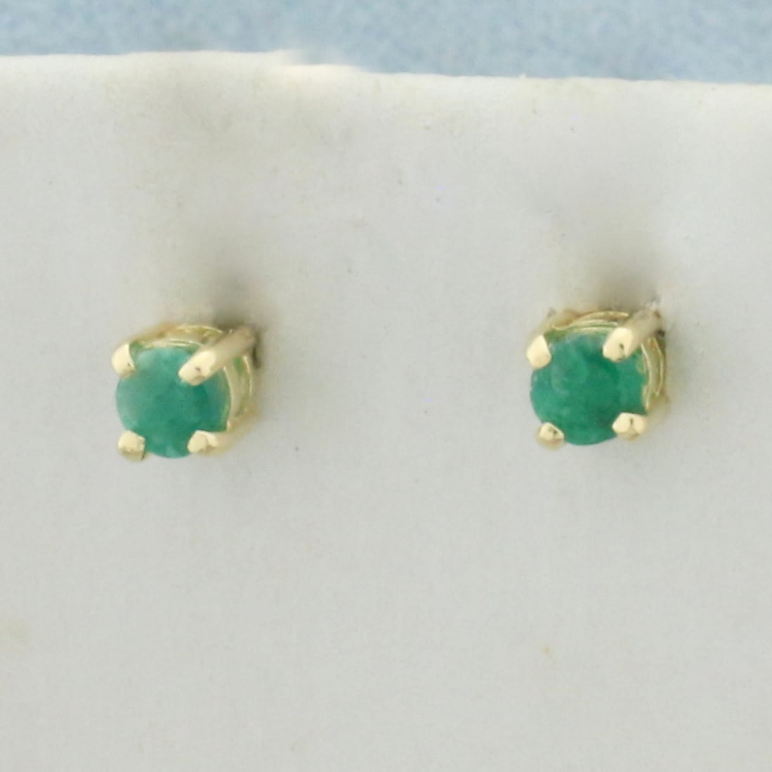 Natural Emerald Stud Earrings in 14k Yellow Gold: In 14k yellow gold basket setting. Contains 2 high quality emeralds, 3mm each, 1/4ct TW, with vibrant color. Friction backs. .7g.