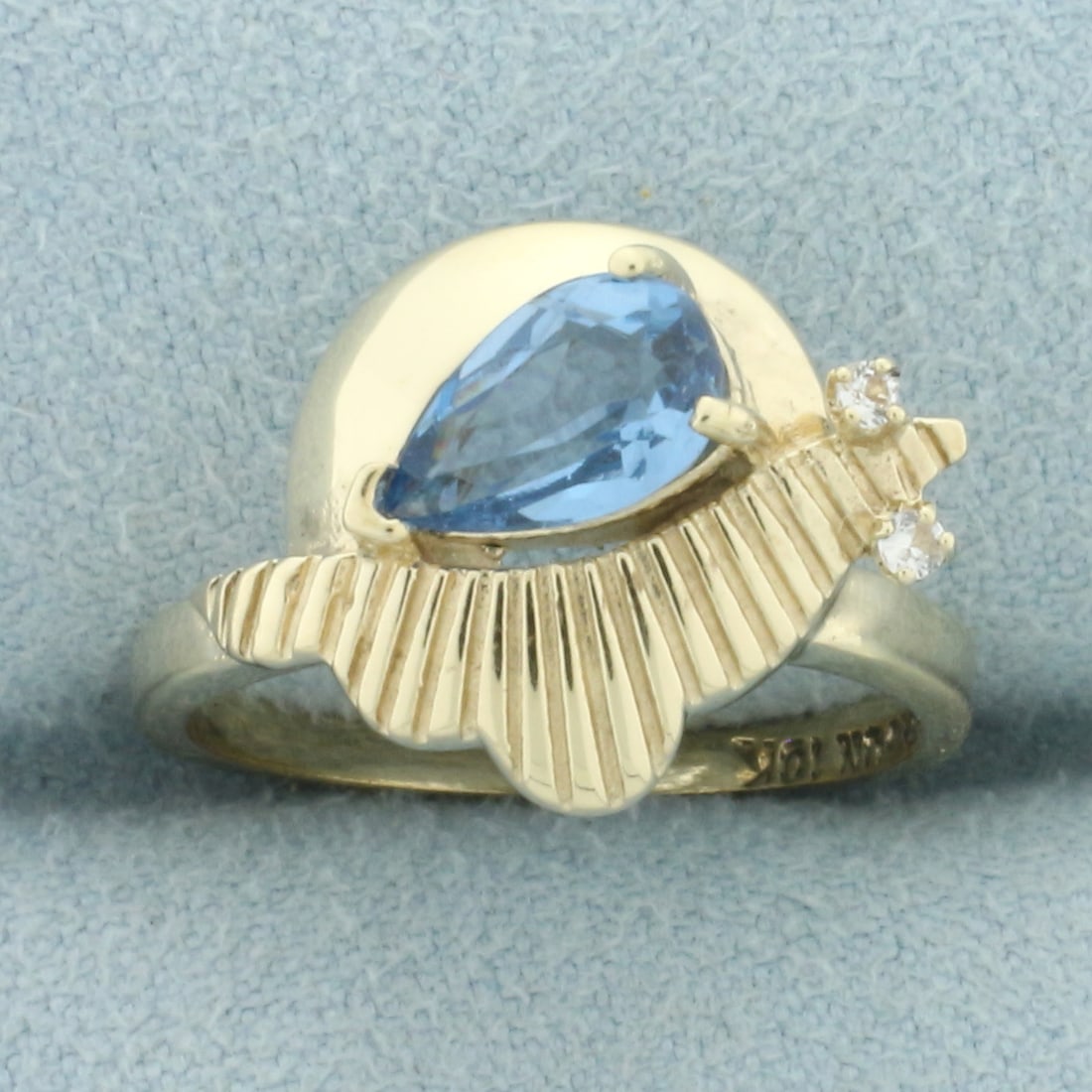 Blue Topaz and Diamond Retro Era Abstract Design Ring in 10k Yellow Gold: In 10k yellow gold. Contain one 8mm high quality natural Swiss Blue Topaz gemstone with electric color and excellent clarity. Also contains two high quality .01ct diamonds, SI clarity/H color. Size: 6