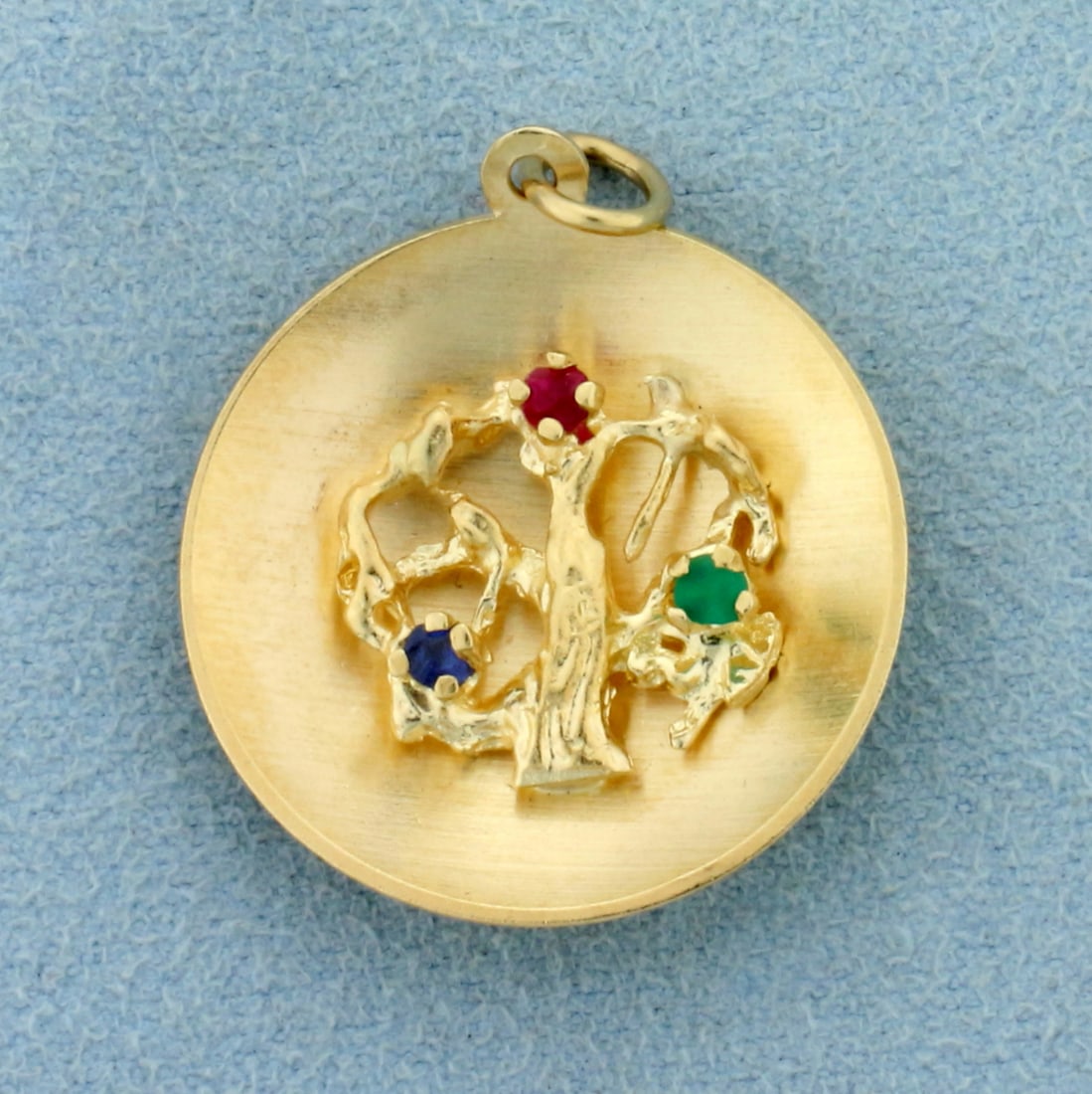 Ancient Tree Pendant in 14K Yellow Gold: In 14K Yellow Gold. Contains three high quality natural 2.25mm Emerald, Ruby and Sapphire gemstones, each with bright color and excellent clarity.1 1/4 inch long including jump ring. 1 inch wide. 4.9g