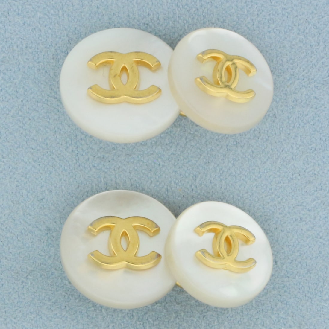 Chanel Mother of Pearl CC Cufflinks: Larger circle is 16mm and smaller circle is 14mm. Yellow gold plated iconic "cc" logos on all mother of pearl circles. Signed on back. In excellent condition. Guaranteed authentic.