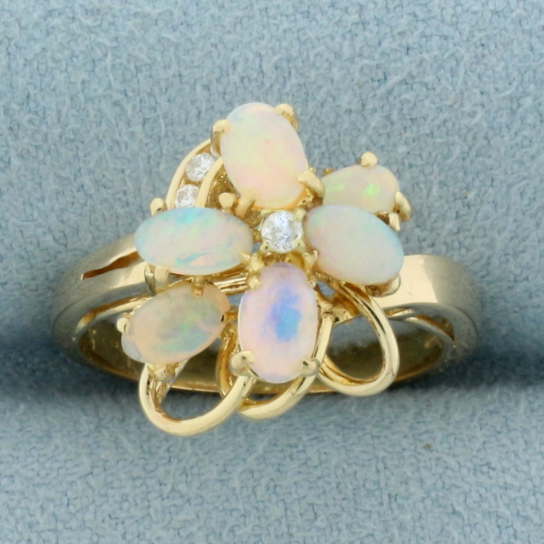 Opal and Diamond Ring in 14k Yellow Gold: In 14k Yellow Gold. Contains six high quality natural 5.25mm oval opal gemstones with intense play of color with flashes of purple, blue, orange, and green. Also contains 6 high quality diamonds, 1/10