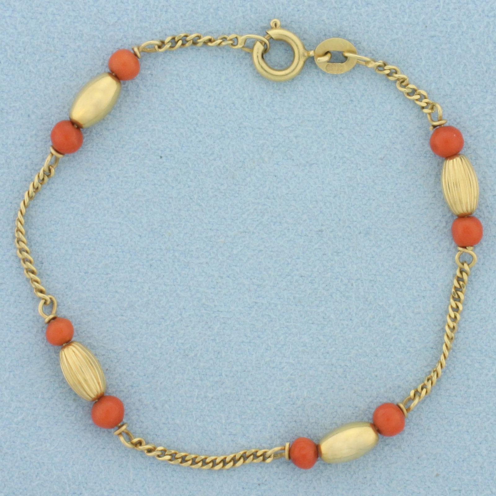 Italian Red Coral and Ball Bead Bracelet in 18k Yellow Gold: In Italian made 18k yellow gold. Contains eight 3.5mm high quality red coral beads and four 4x6mm gold oblong beads. Spring clasp. Six inches long. 3.1g.