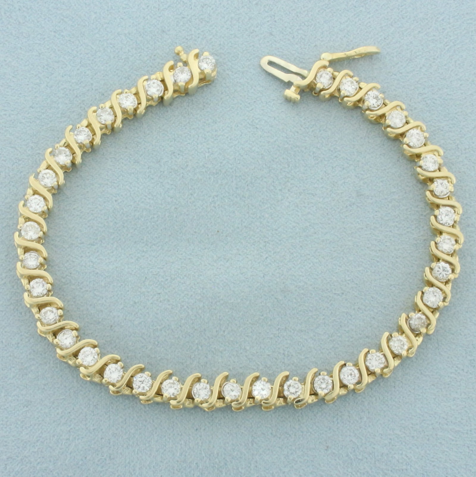 4ct Diamond S-Link Tennis Bracelet in 14k Yellow Gold: In 14k yellow gold. Contains 38 high quality diamonds, 4ct TW, H color/I1 clarity. Concealed slide clasp with safety latch. 7 1/4 inches long. 17.6g.