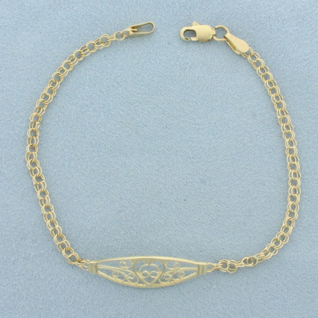 Heart Lace Design Bracelet in 14k Yellow Gold: In 14k yellow gold. 7 inches long, 8.3mm wide at center. Lobster clasp. 2.4g.