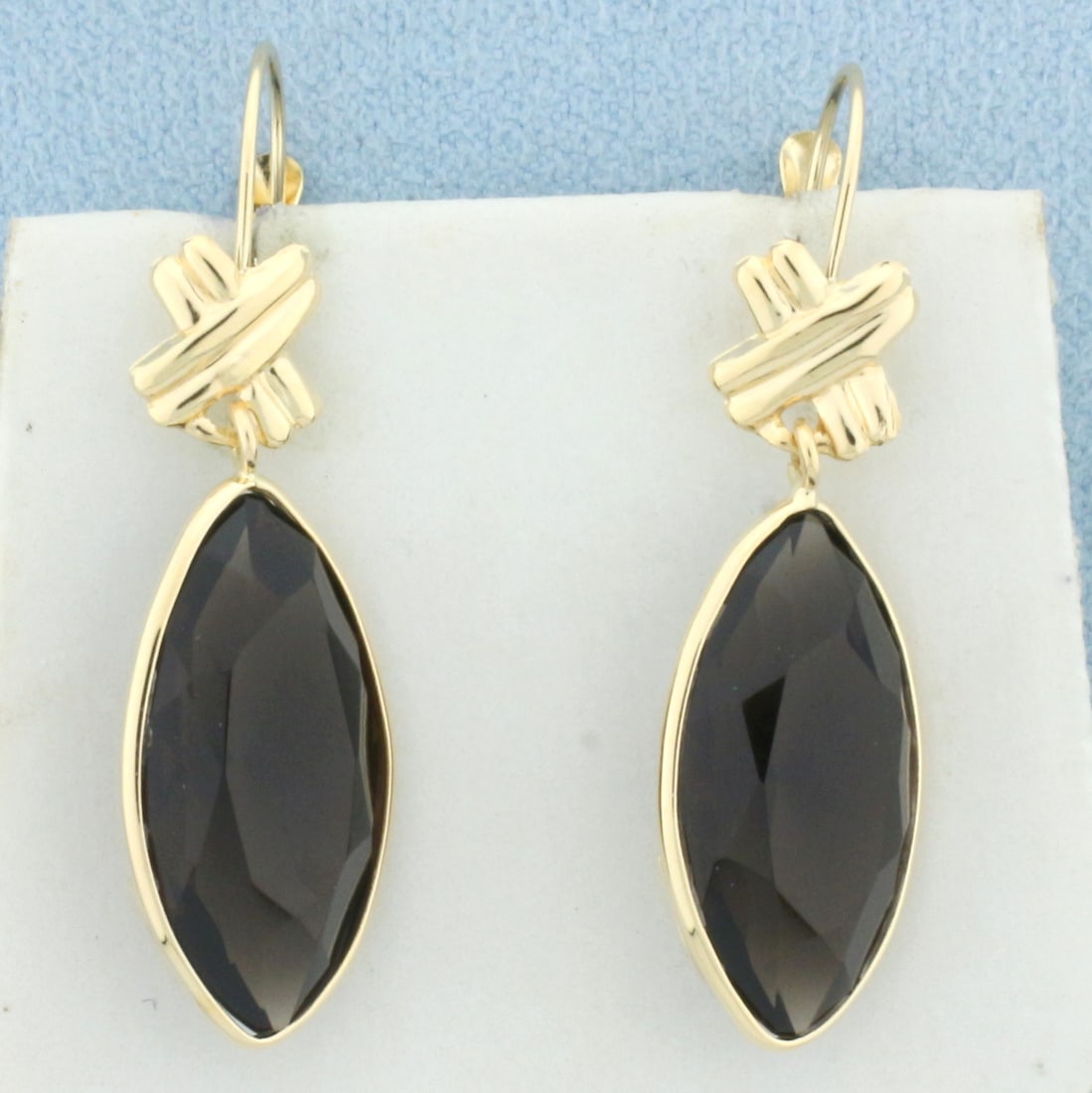 Smoky Quartz Dangle Statement Earrings in 14k Yellow Gold: In 14k yellow gold. Contains 2 marquise cut smoky quartz gemstones, 20 x 10 x 6.5mm, approx. 11ct TW. 1.5 inches long x 3/8 inches wide. Lever backs.