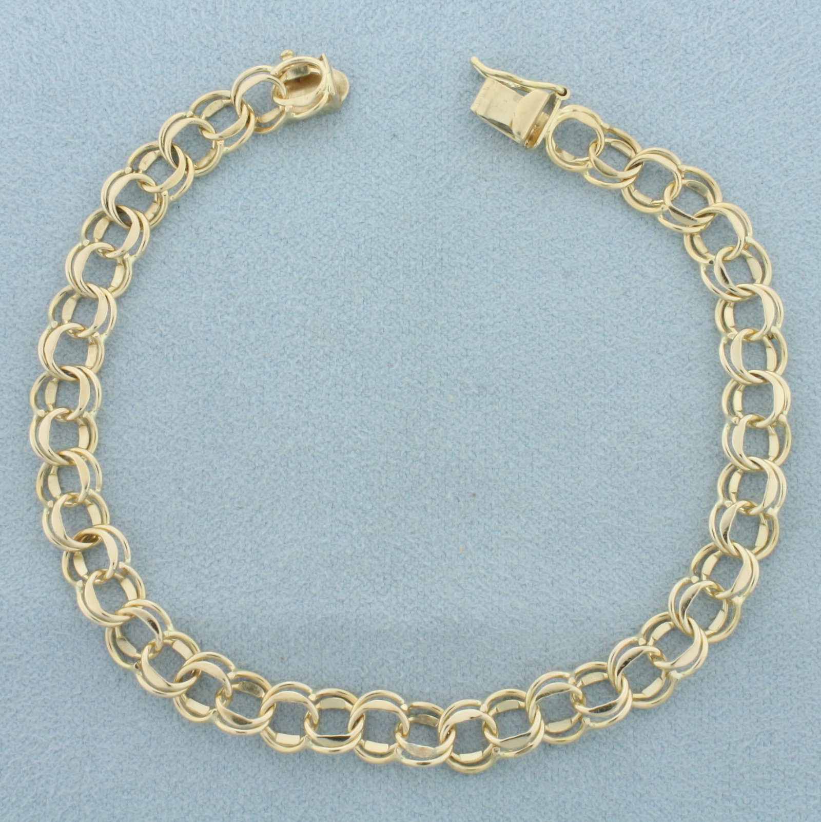 Double Ring Charm Bracelet in 14k Yellow Gold: In 14k yellow gold. 7.5 inches long. 7mm wide. Concealed slide in clasp with safety clasp. 7.7g.