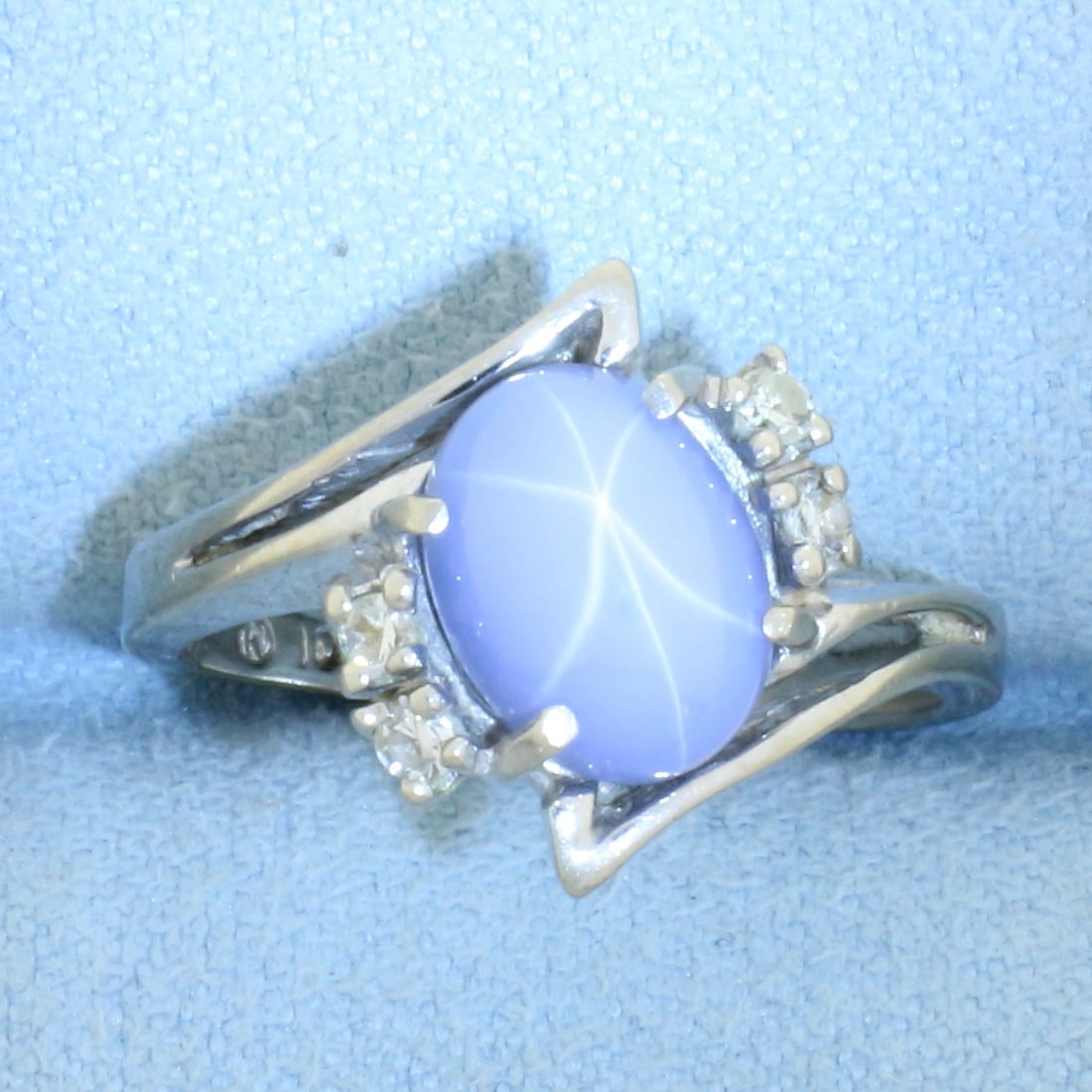 Star Sapphire and Diamond Ring in 10k White Gold: In 10k white gold. Contains one 9mm high quality star sapphire with distinct "star" under light. Also contains 4 high quality .02ct diamonds, SI clarity/H color. Size: 6. 2.7g.