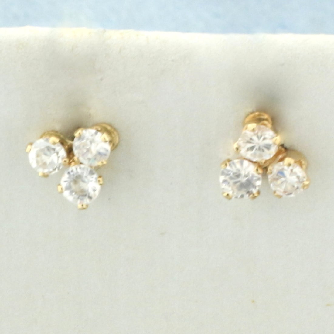 3 Stone CZ Stud Earrings In 14k Yellow Gold: In 14k yellow gold. Contains 6 high quality CZ gemstones, 1/4ct TW, with excellent cut and clarity for extra brilliance. Friction backs. .5g.