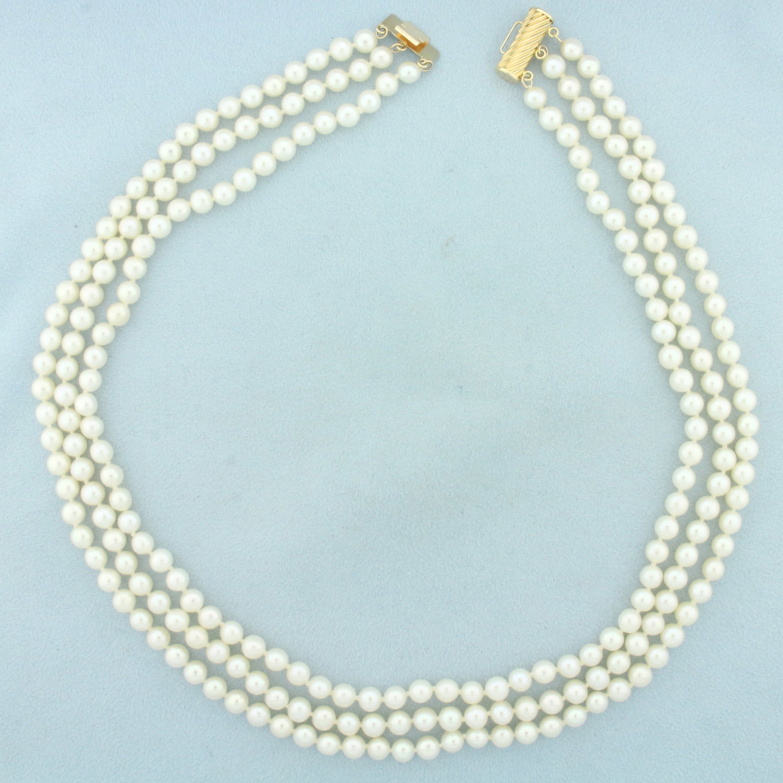 Triple Strand Cultured Pearl Necklace in 14k Yellow Gold: 14k yellow gold clasp. Hand knotted. Shortest strand is 17 inches long. High quality cultured pearls range 5.25mm-5.7mm each with high luster. Decorative locking barrel clasp.