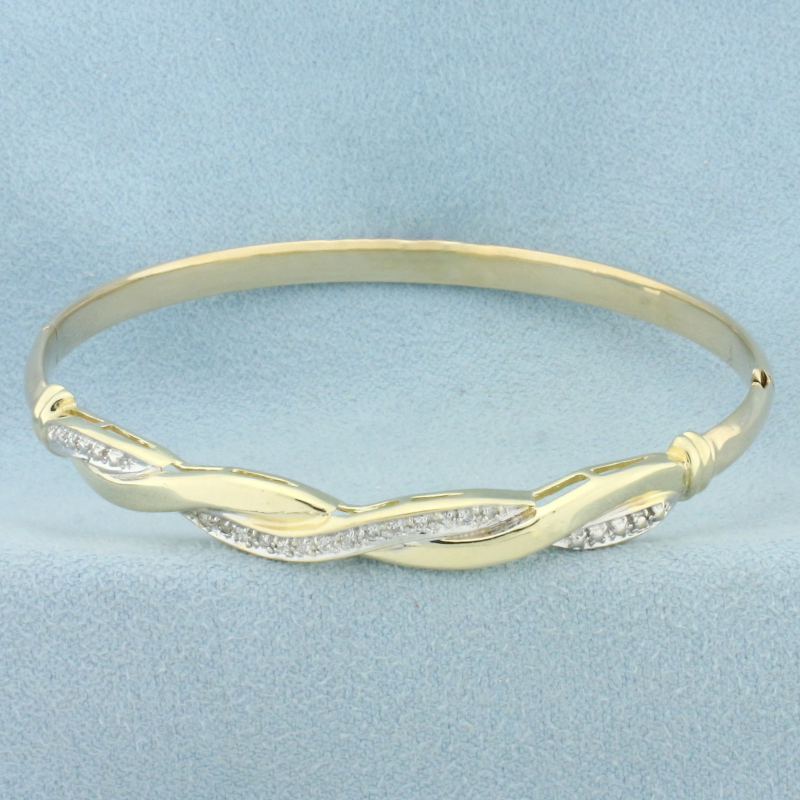 Diamond Twist Hinged Bangle Bracelet in 14k Yellow Gold: In 14k yellow gold and white gold. Contains 14 high quality diamonds, 1/8ctw,SI clarity/H color. Inside dimensions 2 1/4 inches by 2 1/8 inches. Opens/closes for easy putting on and taking off. Slide 