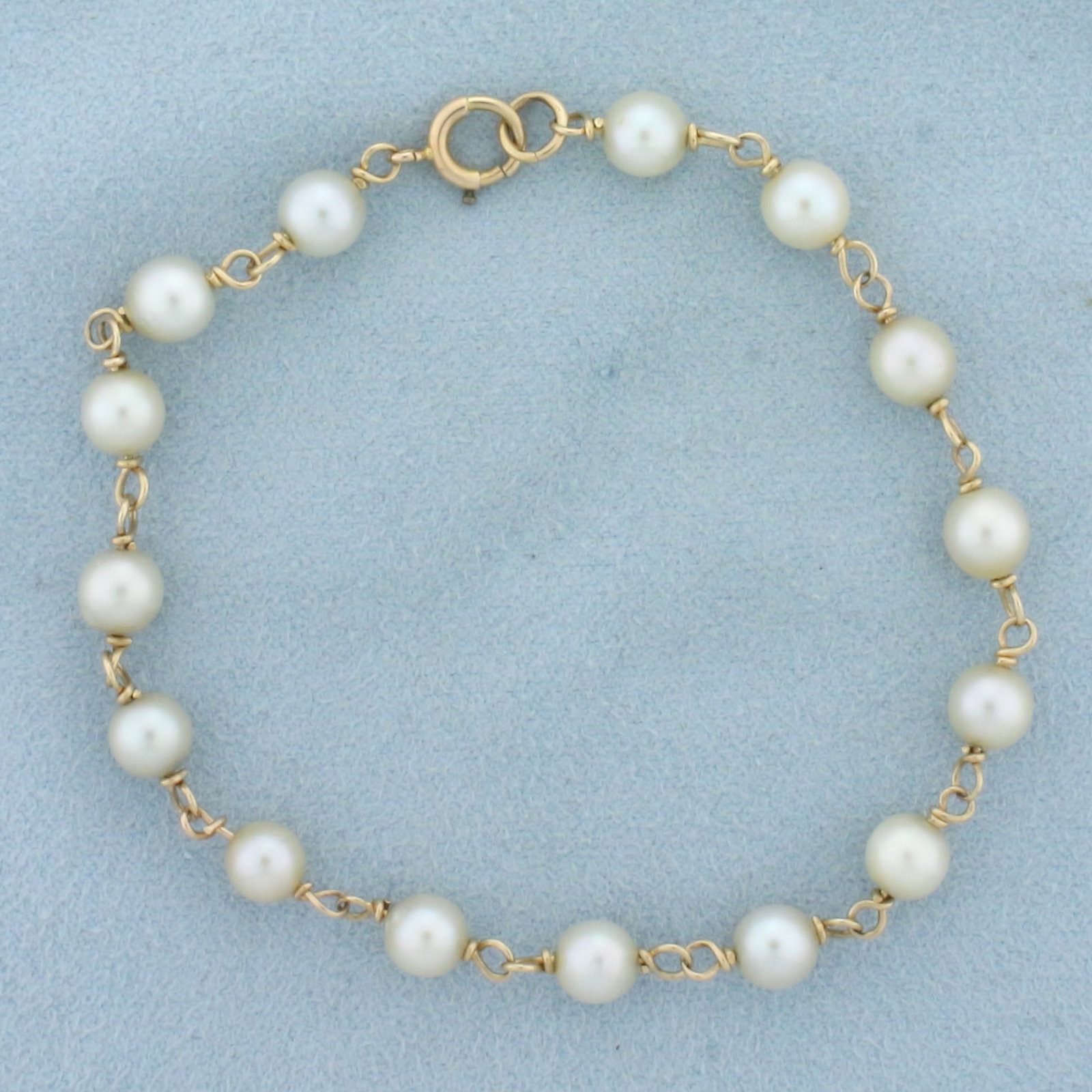 Pearl Station Bracelet in 14k Yellow Gold: In 14k yellow gold. Contains fifteen high quality cultured 5.6mm pearls with high luster. 7 5/8 inches long. Spring Clap. 5.9g.