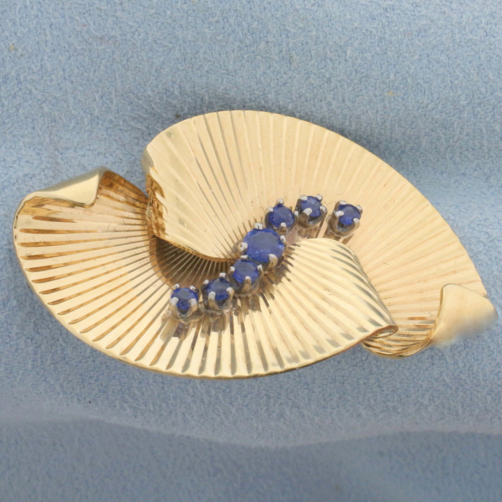 Unique Fan Design Sapphire Pin in 14K Yellow Gold: In 14K Yellow Gold. Contains a high quality natural 3.5mm and six 2.25mm round Sapphire gemstones with intense blue color and excellent clarity. 1 3/4 inches long. 9.3g