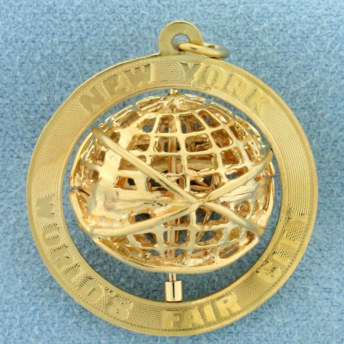 3D Mechanical New York World's Fair City Globe Pendant in 14k Yellow Gold: In 14k yellow gold. "New York World's Fair City" on front with spinning globe. 1 inch in diameter. 5.4g.