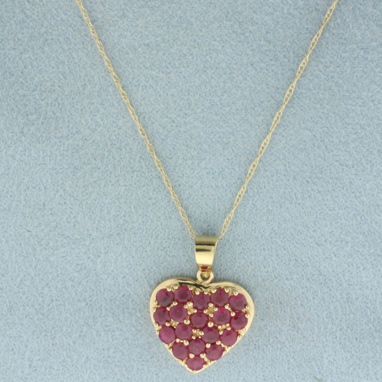 Pave Ruby Heart Necklace in 10k Yellow Gold: In 10k yellow gold. Contains eighteen high quality natural 2.5mm Ruby gemstones, 1ct TW, with vibrant color. Pendant is 3/4 inches x 5/8 inches. Chain is 18 inches long and .7mm wide, spring clasp. 2.
