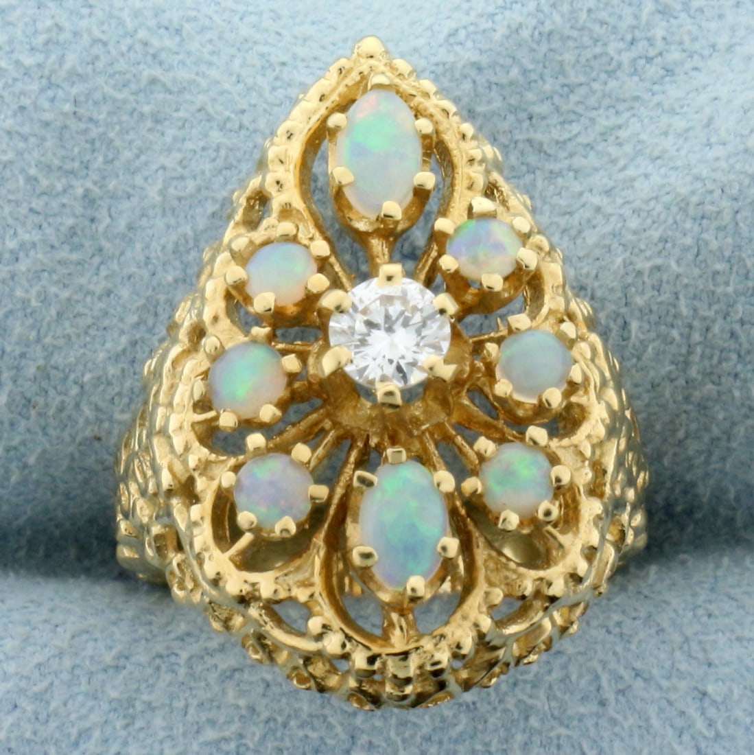 Opal and Diamond Ring in 14K Yellow Gold: In 14K Yellow Gold. Contains one high quality natural 1/4ct Diamond, VS clarity/G color. Also contains two 5x 3mm oval and six high 3.3mm round high quality Opal gemstones with flashes of orange, gree