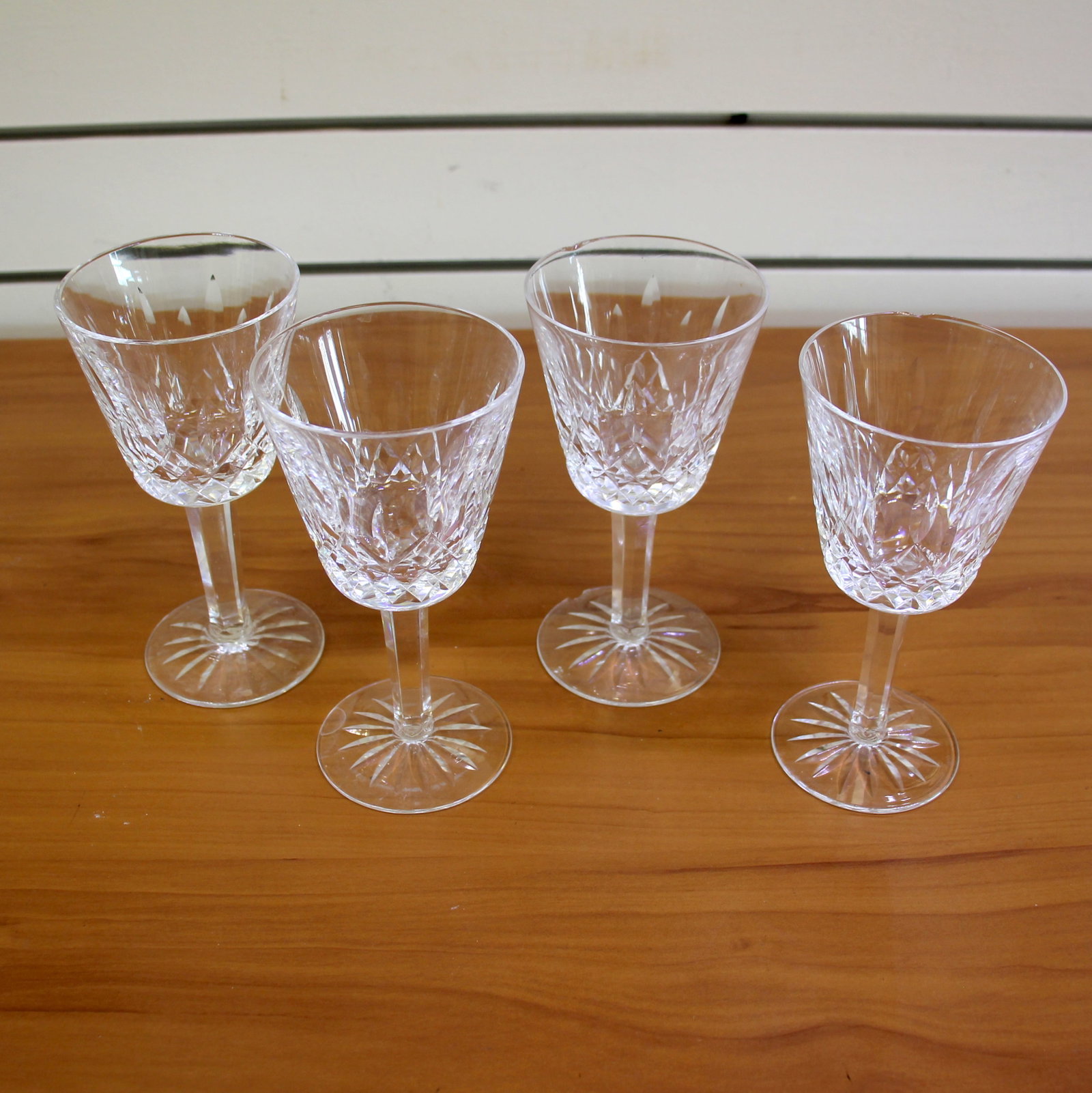 Waterford Lismore Claret Wine Glasses Set of 4: Height: 5 7/8 inches, and width: 3 inches. One glass has small chip on rim and bottom of glass. One glass has small chip at the bottom of glass. Old Gothic lettering markings.