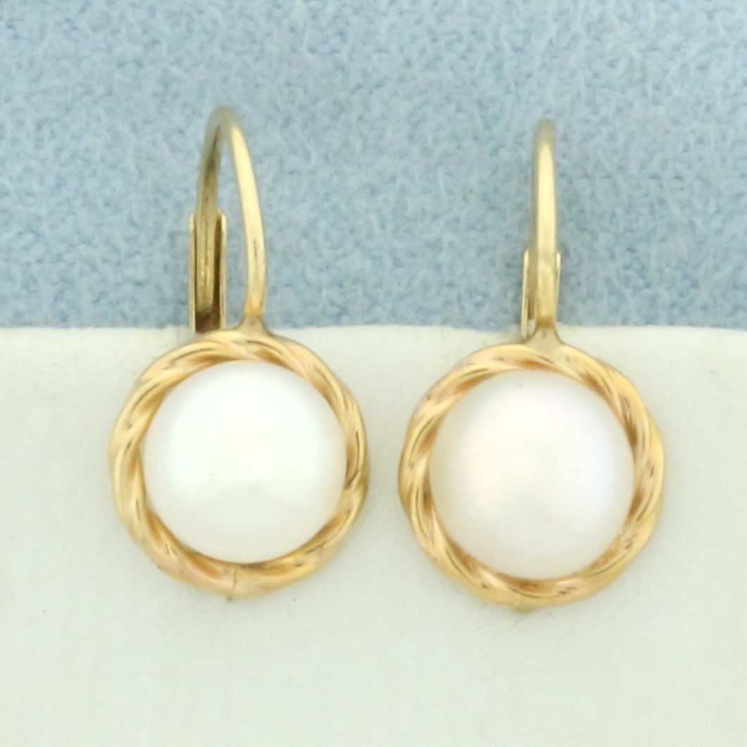 Button Pearl Drop Earrings in 14k Yellow Gold: In 14k yellow gold. Contains two high quality 7mm button Akoya pearls with high luster. 5/8 inches long and 5/16 inches wide. 1.4g.