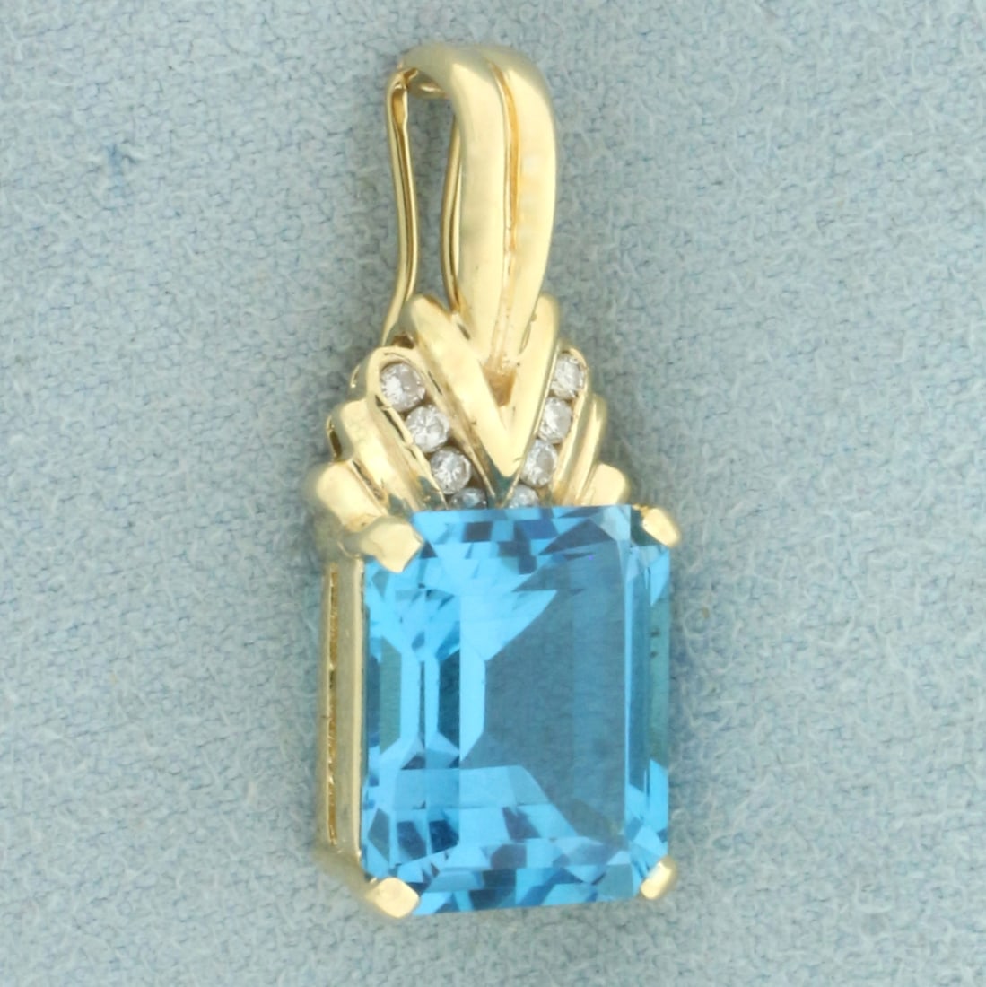 Swiss Blue Topaz and Diamond Pendant in 14k Yellow Gold: In 14k yellow gold. Contains 1 high quality natural emerald cut blue topaz, 10x12mm, 8cts, with electric blue color and excellent clarity. Also contains 8 high quality .01ct diamonds, SI clarity/H col