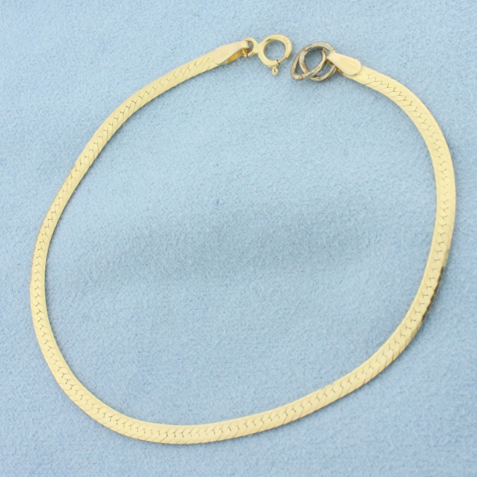 Italian Reversible Herringbone Bracelet in 14k Yellow Gold: In 14k yellow gold. Italian made. 7 1/4 inches long and 2.5mm wide. One side is high polish, other side has diamond cut diagonal pattern. Spring clasp. 2.1g.