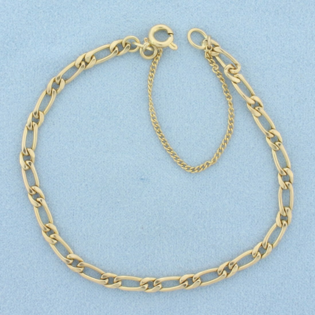 Figaro Link Bracelet in 14k Yellow Gold: 7 inches long and 3.5mm wide. Spring clasp with safety chain. 3.5g.
