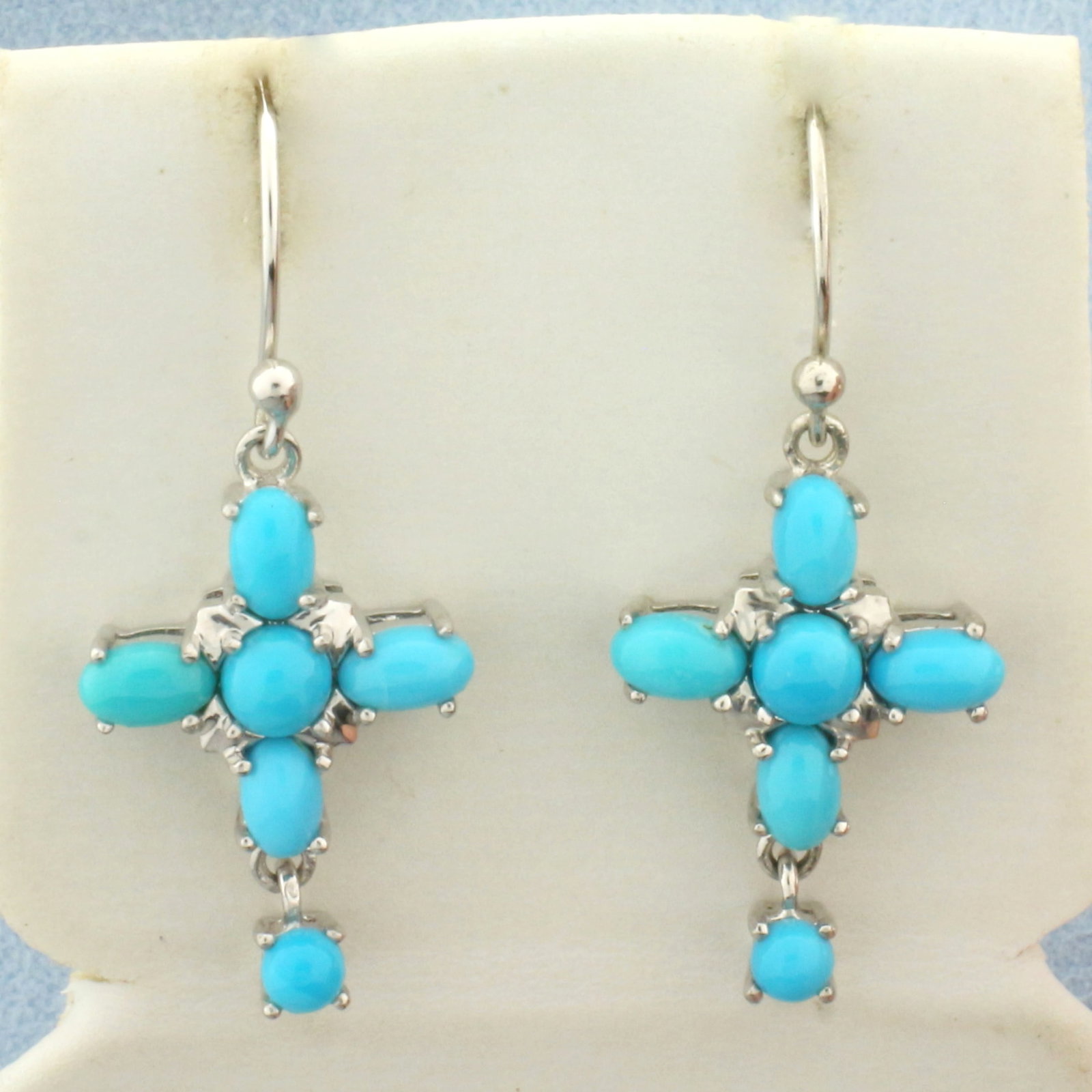 Cross Sleeping Beauty Turquoise Dangle Earrings in Sterling Silver: In .925 sterling silver. Contains twelve Sleeping Beauty Turquoise gemstones with beautiful color. 1 3/8 inches long and 1/2 inches wide. 4.1g