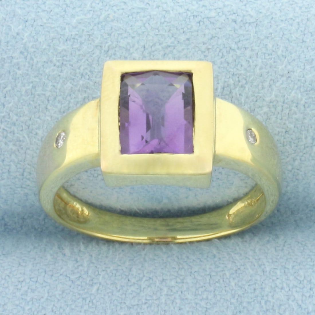 Bezel Set Amethyst and Diamond Ring in 14k Yellow Gold: In 14k yellow gold. Contains one high quality 8mm by 6mm high quality natural fancy checkerboard cut Amethyst gemstone with bright color and excellent clarity. Also contains two high quality .02ct dia