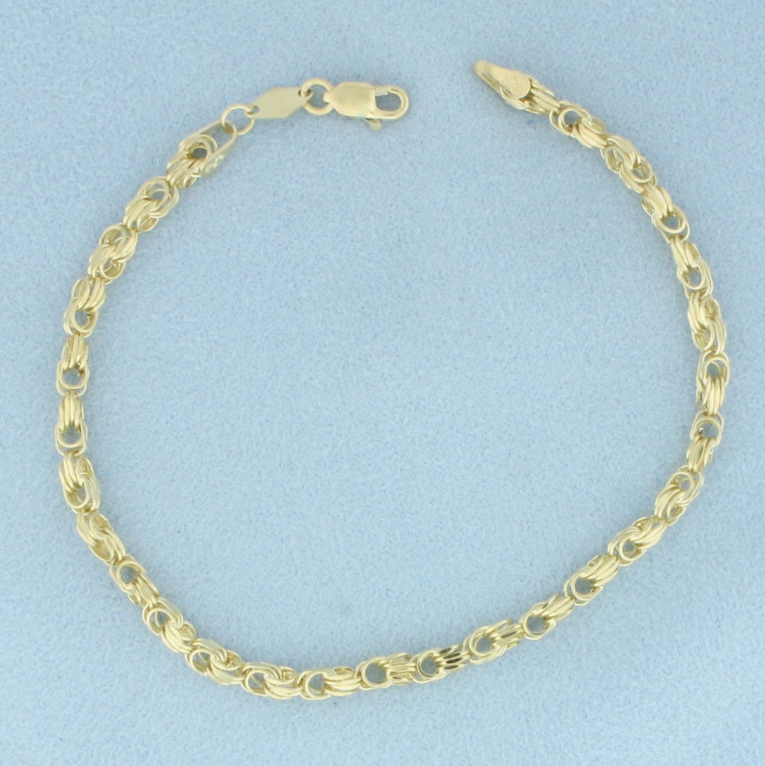 Beveled Designer Chain Link Bracelet in 14k Yellow Gold: In 14k yellow gold. 7 3/8 inches long and 3mm inches wide. Lobster clasp. 2.9g.