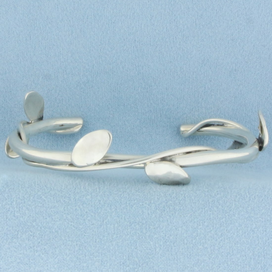 Leaf Vine Design Bangle Bracelet in Sterling Silver: In .925 sterling silver. 2 3/8 inch inner diameter and 5.6mm wide. 15.4g.