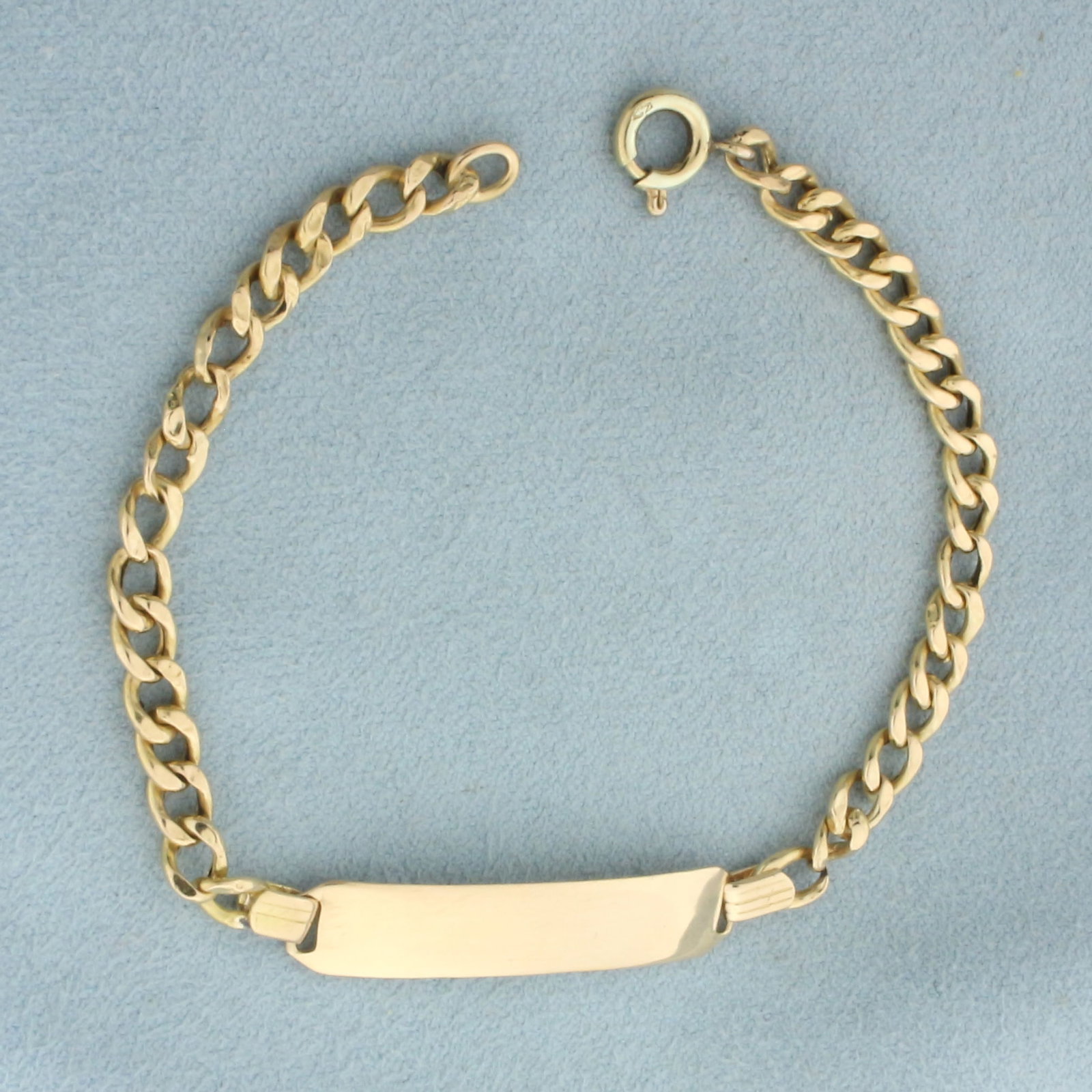 Engravable ID Bracelet in 18k Yellow Gold: In 18k yellow gold. . 7 inches long and 1/4 inch wide at widest spot. Engravable area 1 1/4 inches long. Spring clasp. 4.6g.