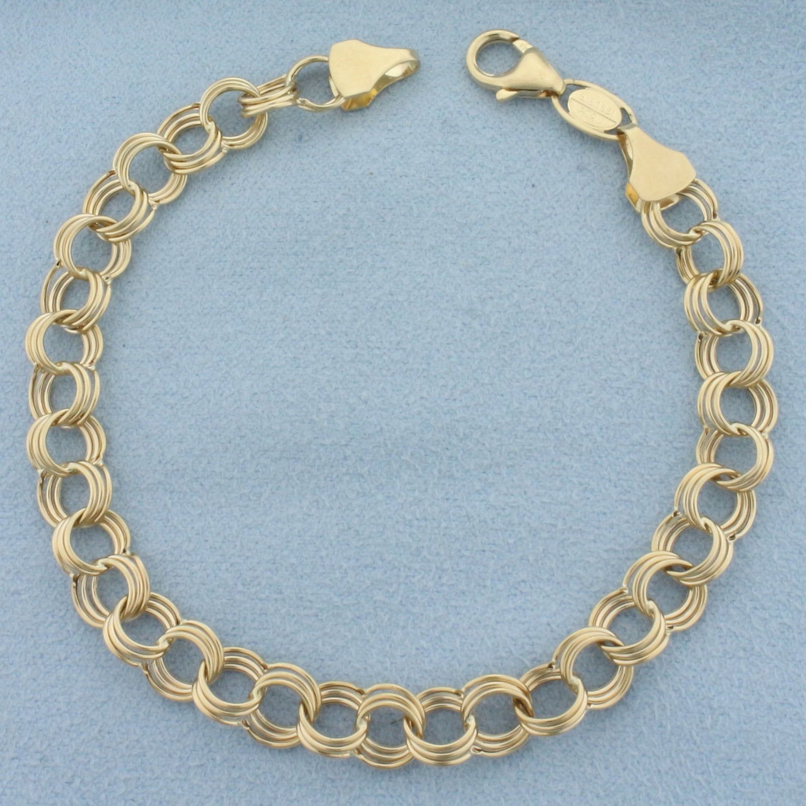 Triple Ring Charm Bracelet in 14k Yellow Gold: In 14k yellow gold. 7.5 inches long and 1/4 inch wide. Lobster clasp. 4.0g.