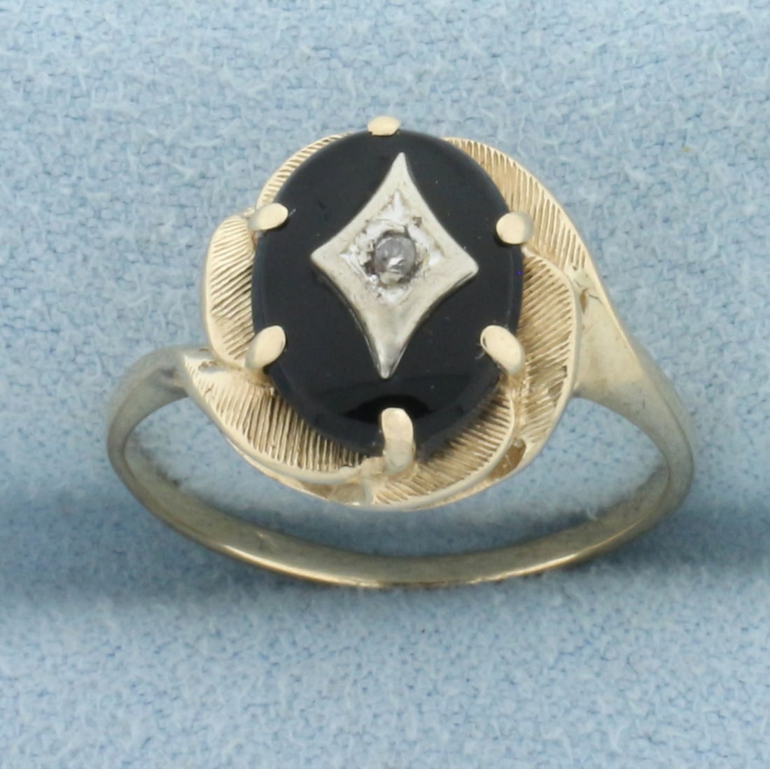 Vintage Diamond and Onyx Ring in 10k Yellow Gold: In 10k yellow gold. 10mm by 8mm, black onyx oval plaque. Also contains one high quality .01ct diamond, SI clarity/I color. 12.3mm wide at top. Size: 6. 2.4g.