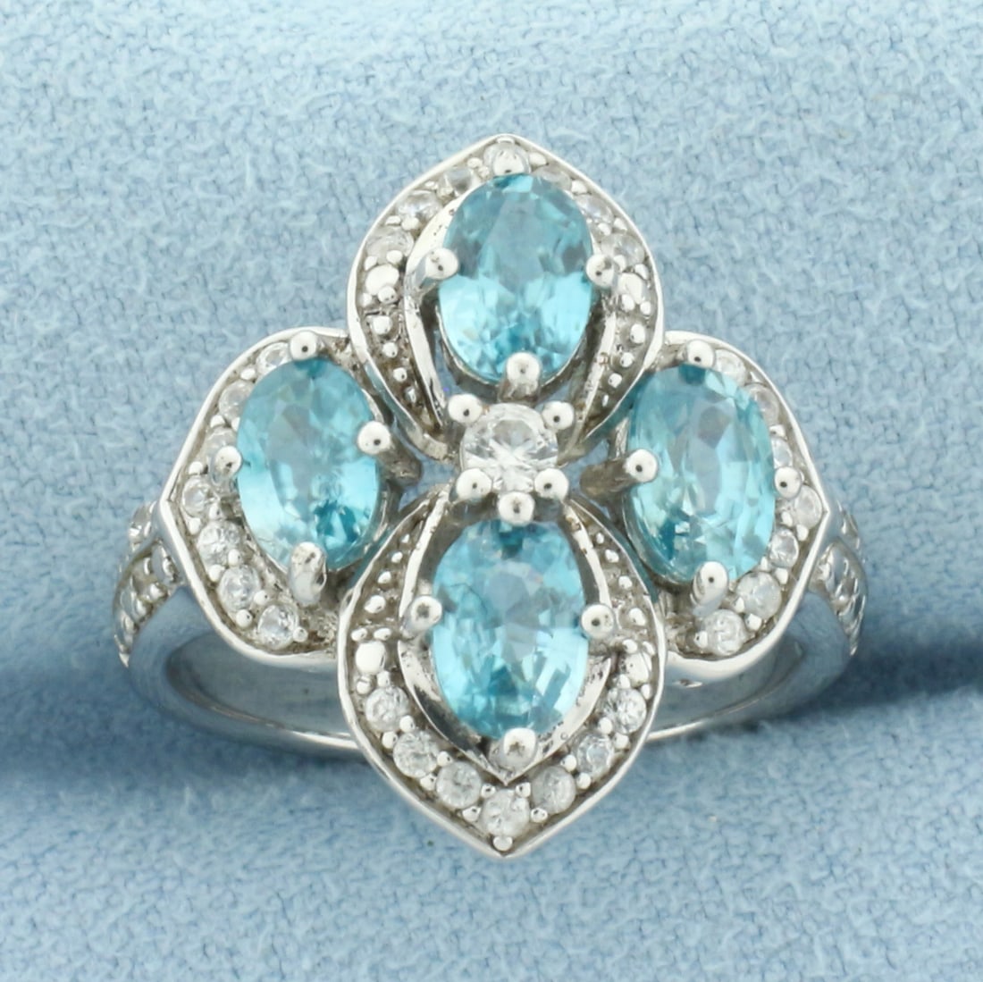 Blue Zircon Ring in Sterling Silver: In .925 sterling silver. Contains 4 oval cut blue zircon, 6 by 4mm each, excellent color and clarity. Also contains one 2.5mmand thirty-two 1mm White Sapphire gemstones, excellent clarity . Measures 3