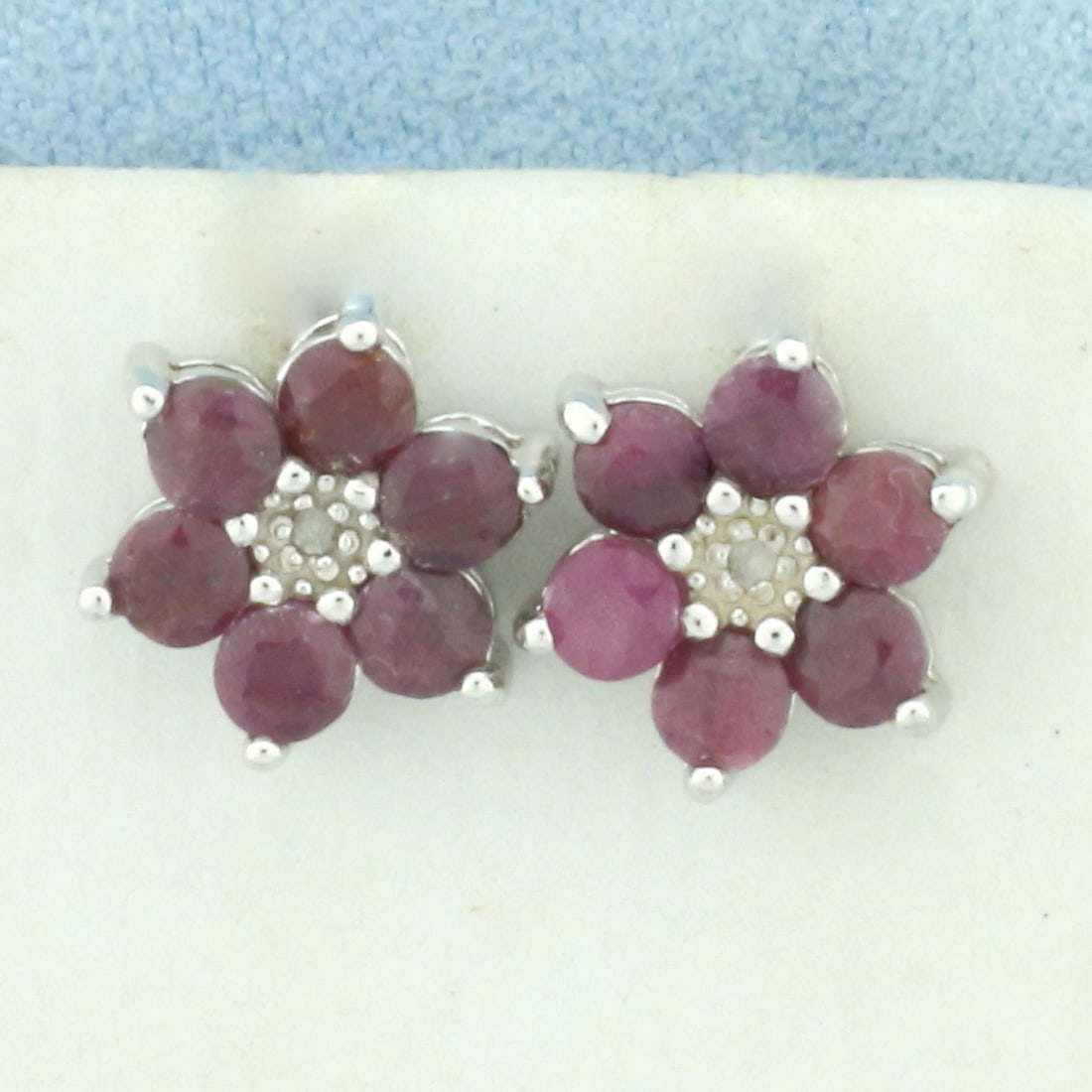 Ruby and Diamond Flower Earrings in Sterling Silver: In .925 sterling silver. Contains twelve high quality natural Ruby gemstones, 1.6ct Tw, with intense color. Also contains two 1/2pt diamonds. 3/8 inches diameter. Friction backs. 2.2g.