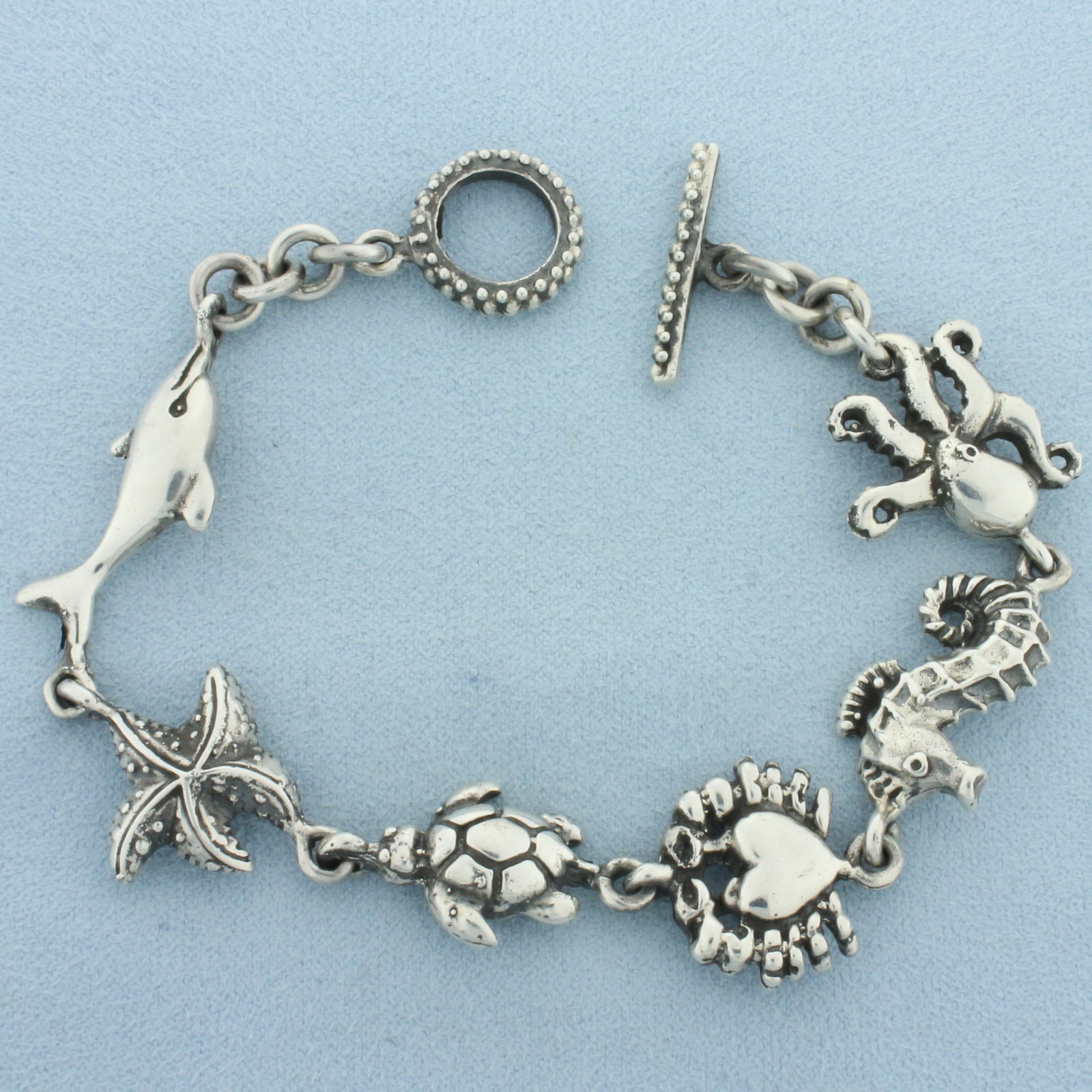 Unique Sea Life Link Bracelet in Sterling Silver: In .925 sterling silver. Contains Octopus, Seahorse, Heart, Turtle, Starfish, and Dolphin links. 8 inches long and 23mm wide. 23.3g