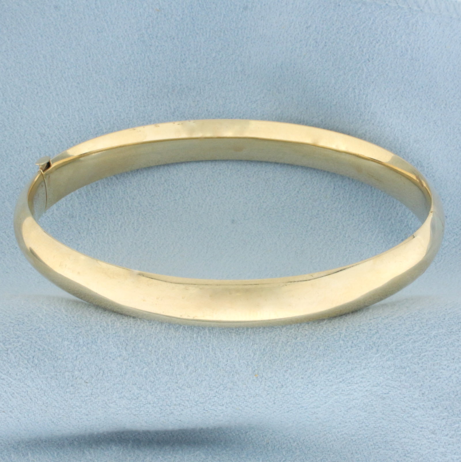 High Polish Hinged Classic Bangle Bracelet in 14k Yellow Gold: In 14k yellow gold. 8mm wide. 2.5 inches x 2 1/4 inches interior dimensions. Opens/closes for easy putting on and taking off. Slide Bar locking hinged closure. 8.8g.