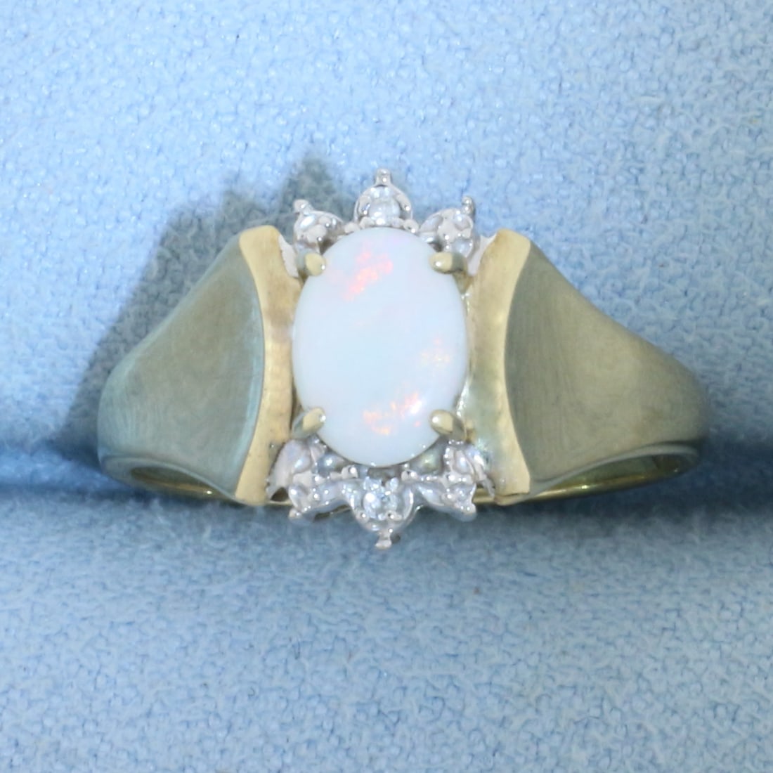Opal and Diamond Ring In 10k Yellow Gold: In 10k Yellow Gold. Contains one high quality natural 5mmx7mm Opal Gemstone with excellent play of color with flashes of pink, green, and yellow. Also contains two 1/2pt diamonds. Size 6.5. 2.1g.